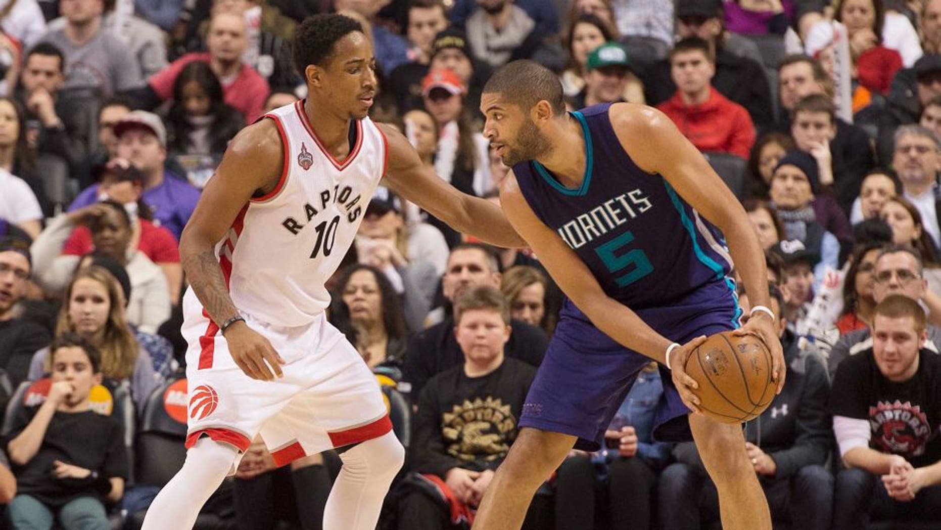 Jan 1, 2016; Toronto, Ontario, CAN;Charlotte Hornets guard Nicolas Batum (5) looks to play a ball as Toronto Raptors guard DeMar DeRozan (10) tries to defend during the third quarter in a game at Air Canada Centre. The Toronto Raptors won 104-94. Mandatory Credit: Nick Turchiaro-USA TODAY Sports