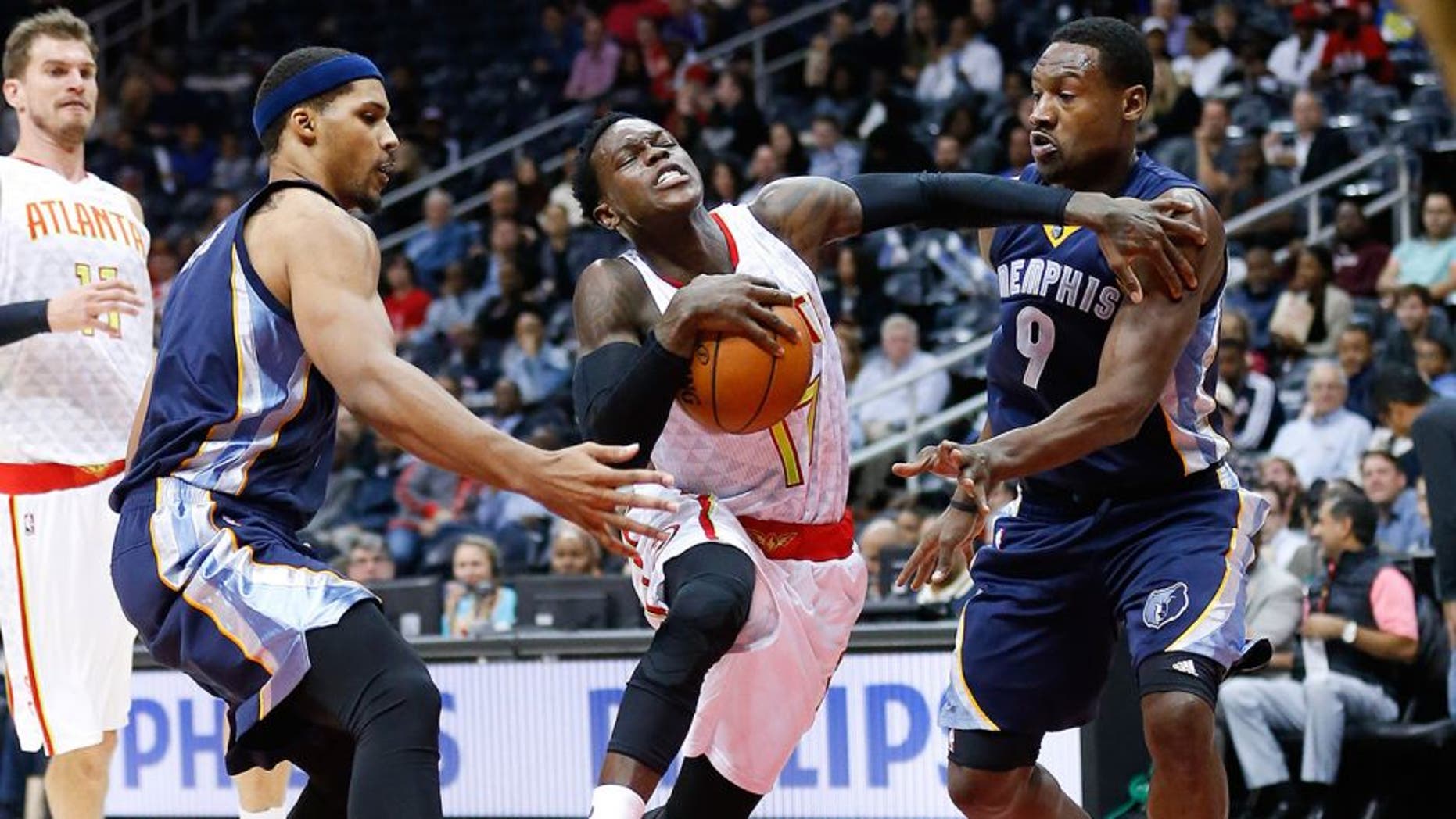 Atlanta Hawks guard Dennis Schroder (17) drives between Memphis Grizzlies' Jarnell Stokes (1) and Tony Allen (9) in the first half of an NBA basketball game Wednesday, Oct. 21, 2015, in Atlanta. (AP Photo/John Bazemore)