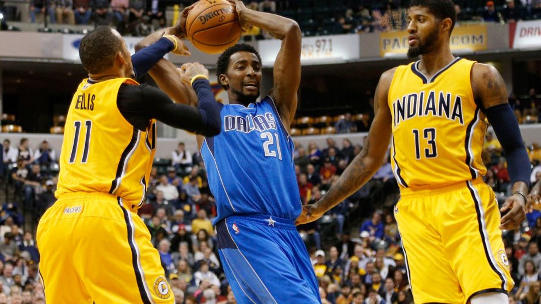 Dec 16, 2015; Indianapolis, IN, USA; Dallas Mavericks forward Jeremy Evans (21) is guarded by Indiana Pacers guard Monta Ellis (11) and forward Paul George (13) at Bankers Life Fieldhouse. Indiana defeats Dallas 107-81. Mandatory Credit: Brian Spurlock-USA TODAY Sports