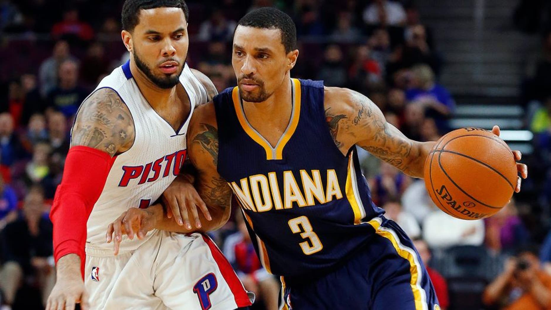 Indiana Pacers guard George Hill (3) drives against Detroit Pistons guard D.J. Augustin (14) in the first half of an NBA basketball game in Auburn Hills, Mich., Friday, Dec. 26, 2014. (AP Photo/Paul Sancya)