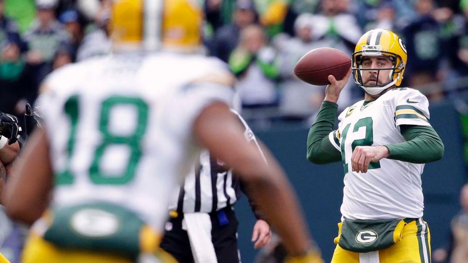 The Green Bay Packers' Aaron Rodgers (right) looks to pass to Randall Cobb during the first half of the NFC championship game in Seattle.