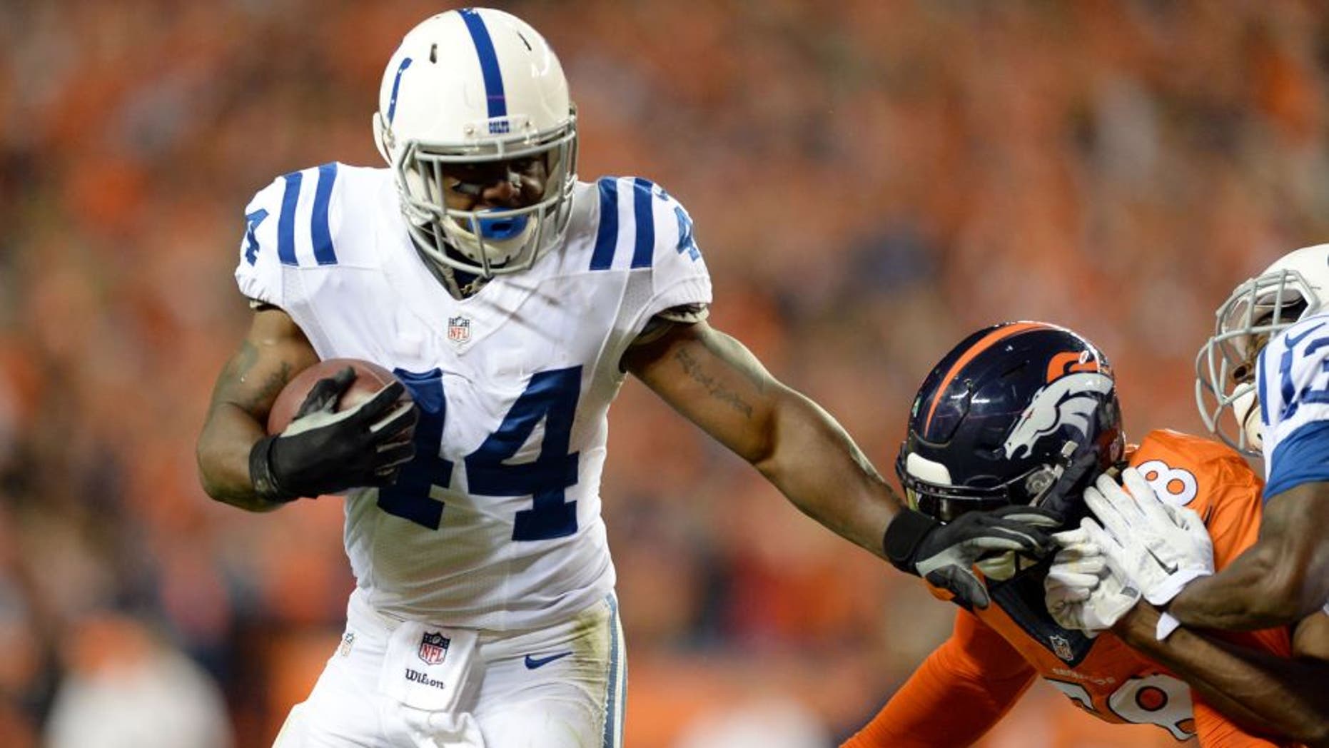 Sep 7, 2014; Denver, CO, USA; Indianapolis Colts running back Ahmad Bradshaw (44) stiff arms Denver Broncos outside linebacker Von Miller (58) in the third quarter at Sports Authority Field at Mile High. The Broncos defeated the Colts 31-24. Mandatory Credit: Ron Chenoy-USA TODAY Sports