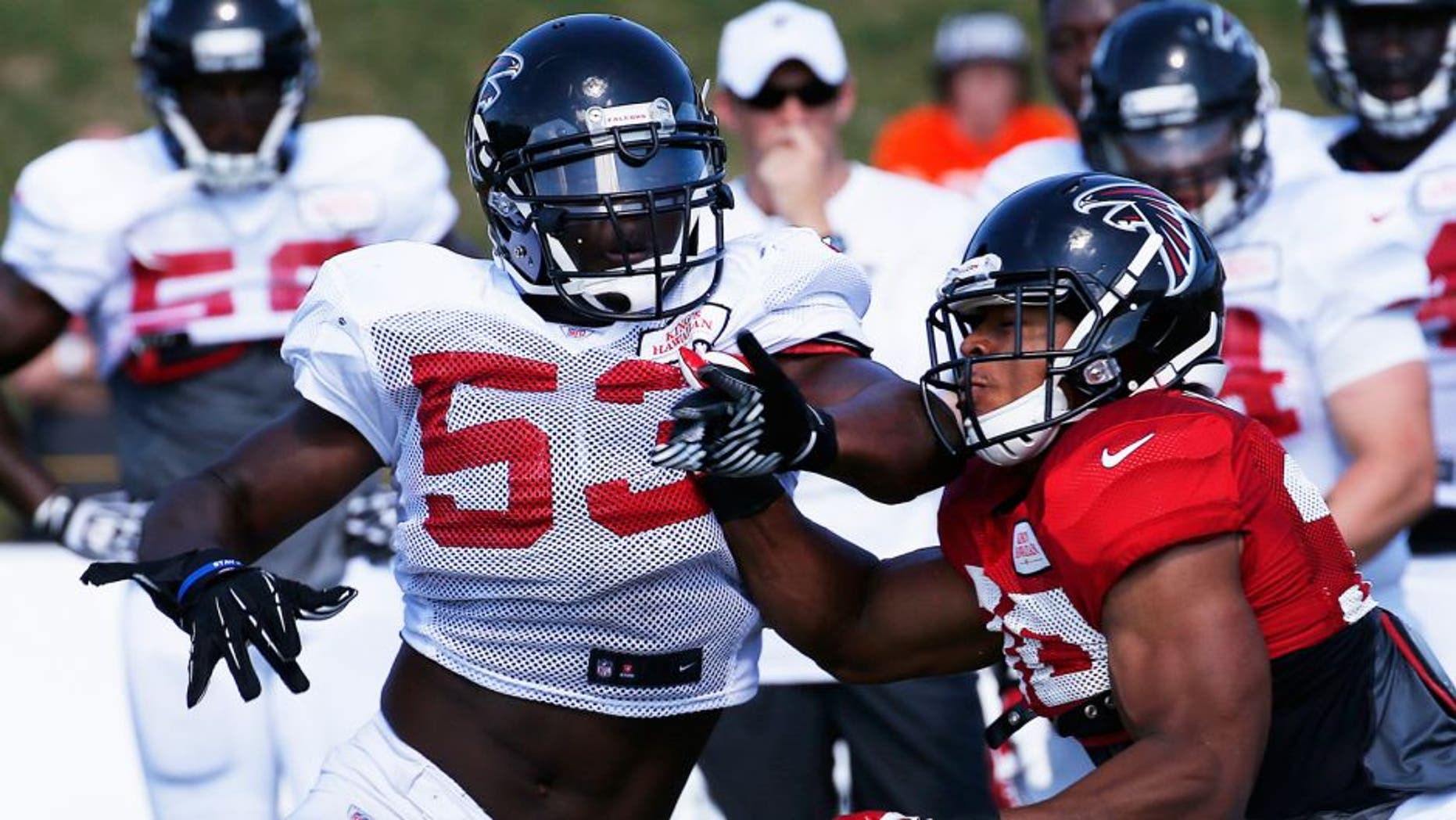 Atlanta Falcons linebacker Prince Shembo (53) works against Atlanta Falcons running back Josh Vaughan (30) during an NFL football training camp Monday, July 28, 2014, in Flowery Branch, Ga. (AP Photo/John Bazemore)