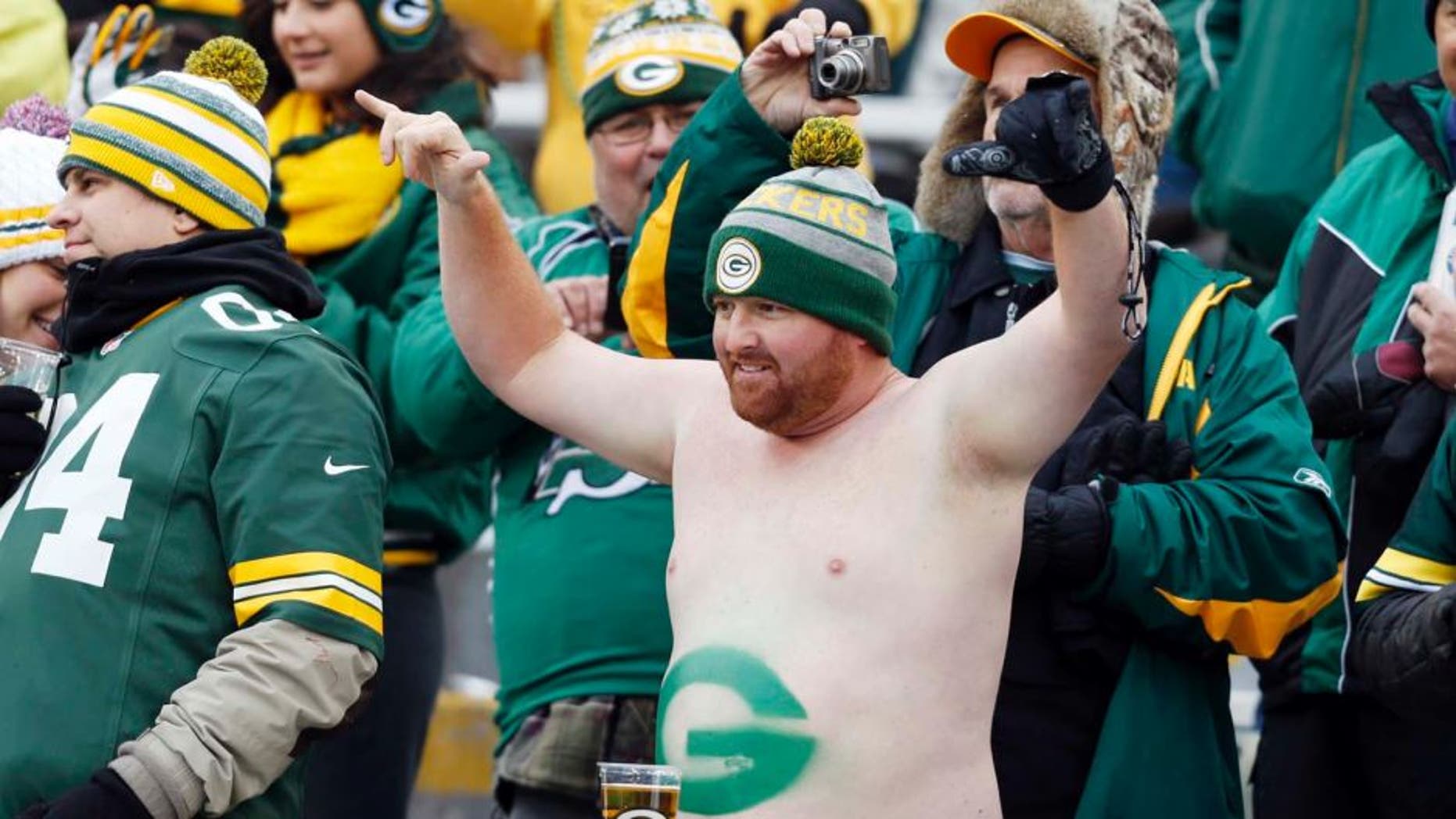 Green Bay Packers fan Cody Drinkle takes his shirt off in the stands during the first half.