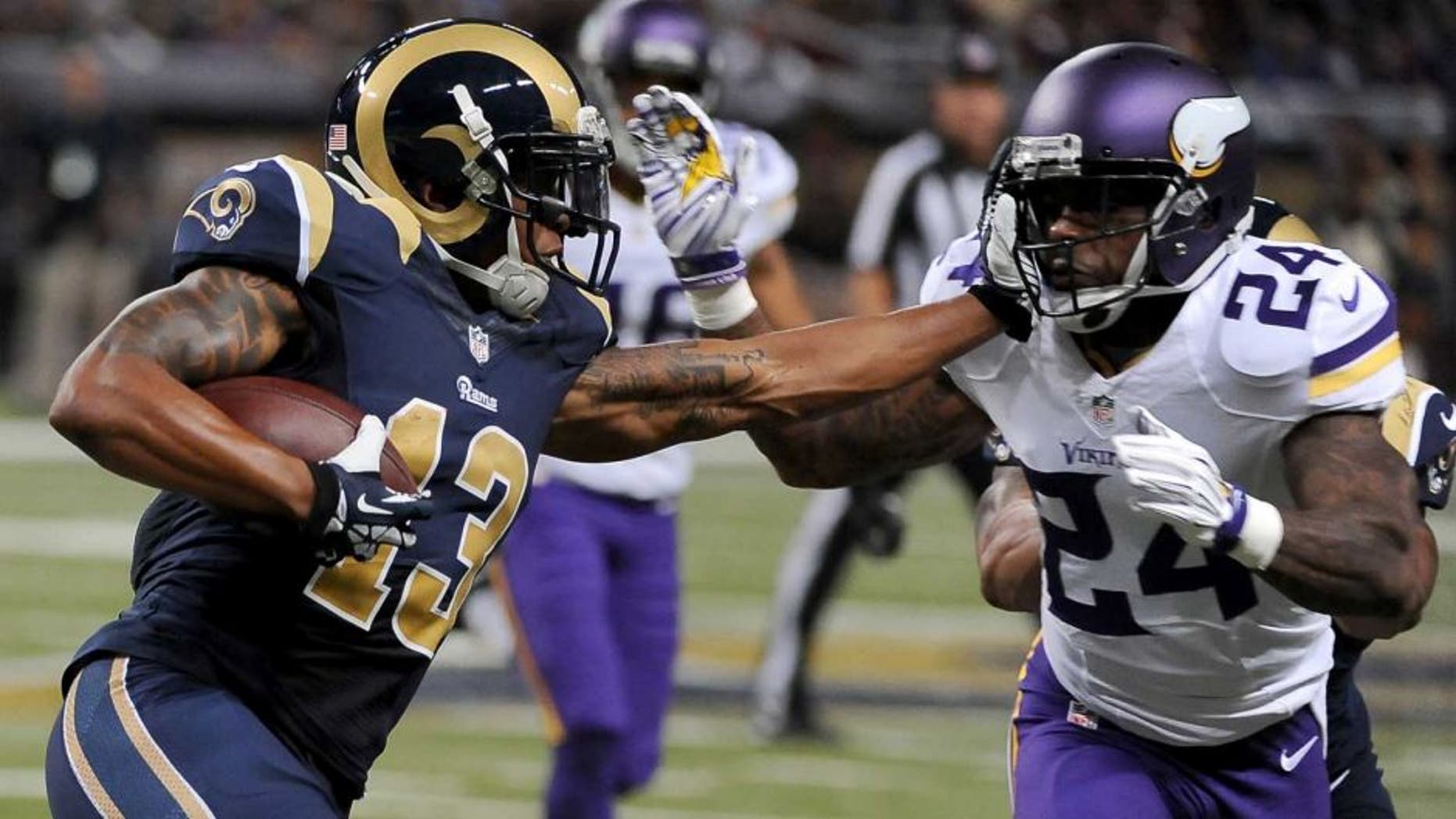 St. Louis Rams wide receiver Chris Givens (left) runs with the ball for a 4-yard gain before being stopped by Minnesota Vikings cornerback Captain Munnerlyn during the second quarter in St. Louis. Munnerlyn was also given a 15-yard unnecessary roughness penalty on the play.