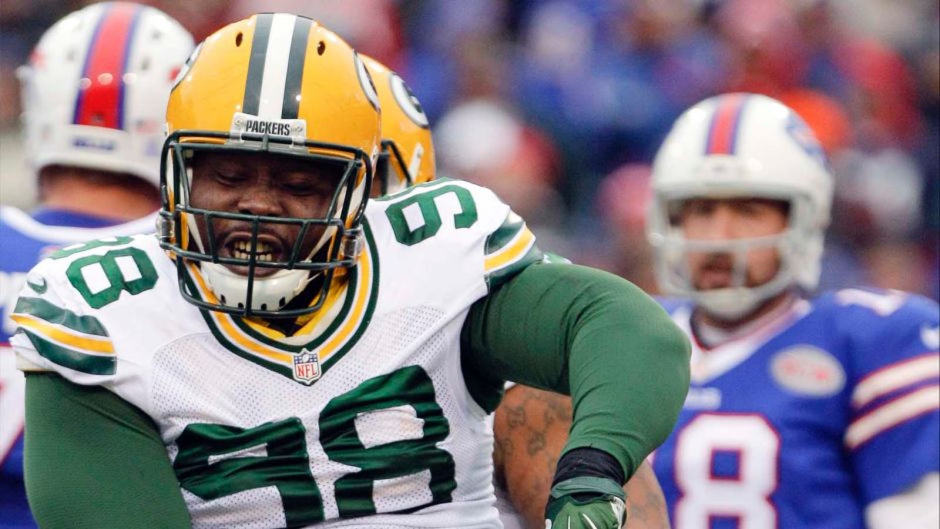 Green Bay Packers nose tackle Letroy Guion celebrates a sack of Buffalo Bills quarterback Kyle Orton (back) during the first half.