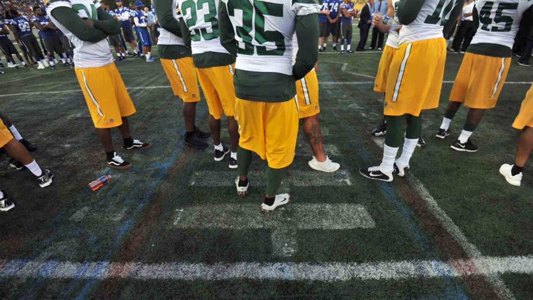 Green Bay Packers players stand on the center logo, which was deemed unsafe for play at the 2016 Hall of Fame Game at Tom Benson Hall of Fame Stadium in Canton, Ohio, on Sunday, Aug. 7, 2016.