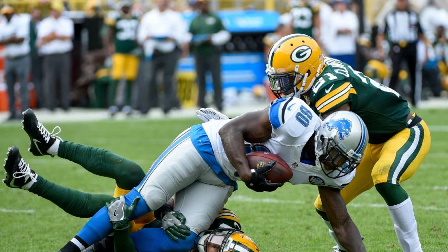Detroit Lions wide receiver Anquan Boldin is tackled by Green Bay Packers defensive back Micah Hyde and safety Ha Ha Clinton-Dix.
