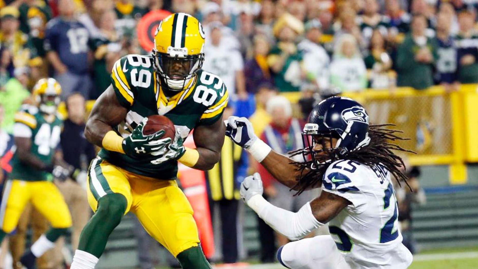 The Green Bay Packers' James Jones catches a touchdown pass in front of the Seattle Seahawks' Richard Sherman during the first half of an NFL football game Sunday, Sept. 20, 2015, in Green Bay, Wis.