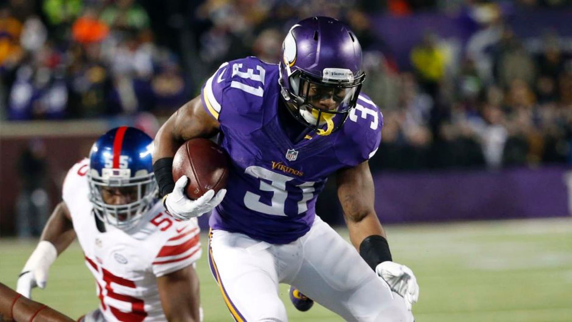 Minnesota Vikings running back Jerick McKinnon jumps over New York Giants defenders during the first half Sunday, Dec. 27, 2015, in Minneapolis.