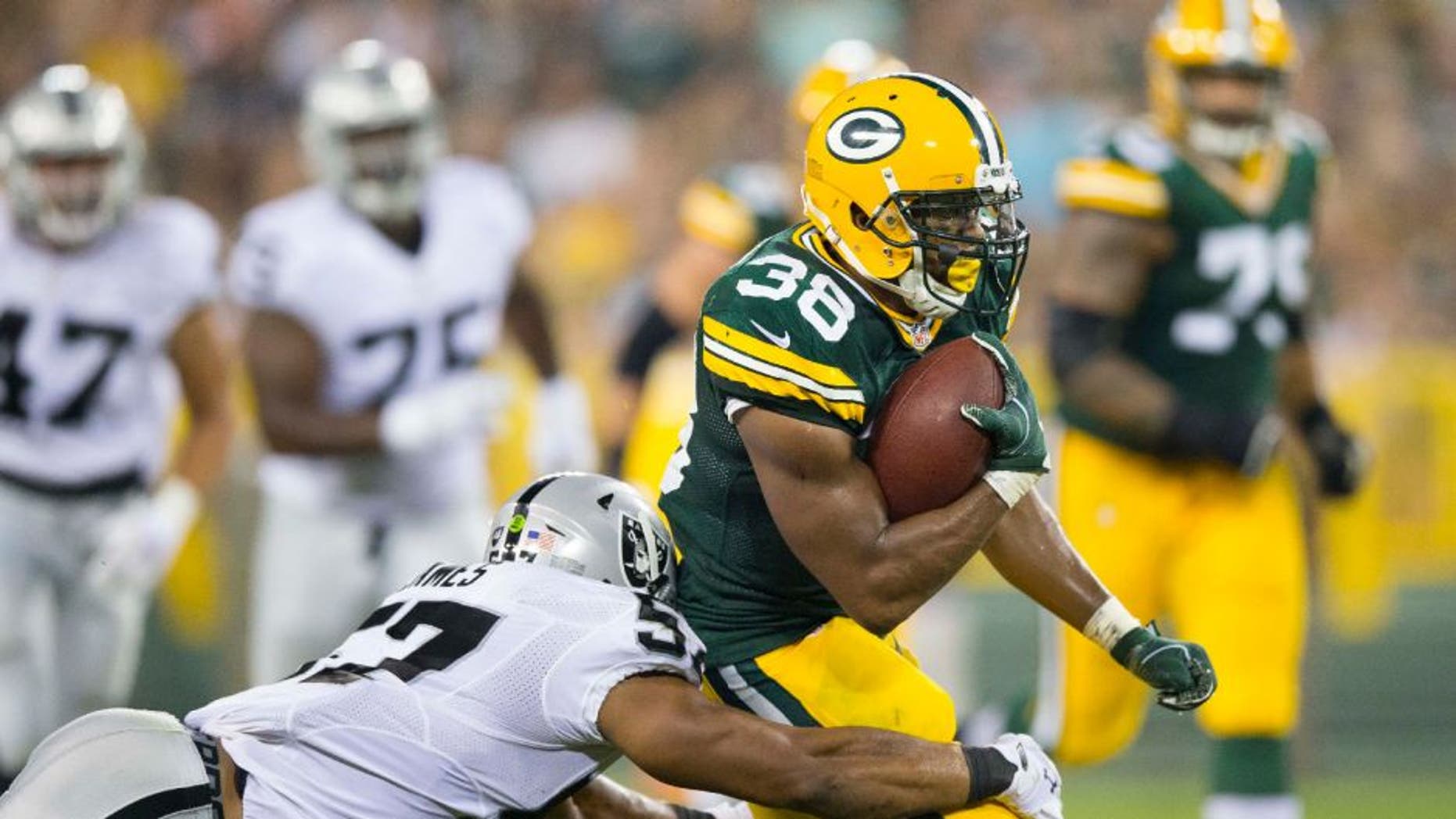 Oakland Raiders linebacker Cory James tackles Green Bay Packers running back John Crockett during the third quarter at Lambeau Field.