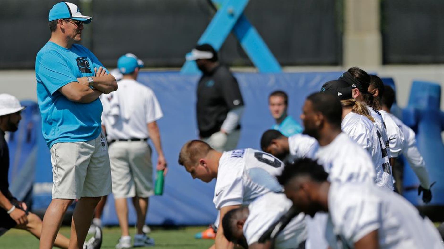 Carolina Panthers head coach Ron Rivera, left, watches players warm up during a practice at the NFL football team's rookie minicamp in Charlotte, N.C., Friday, May 8, 2015. (AP Photo/Chuck Burton)
