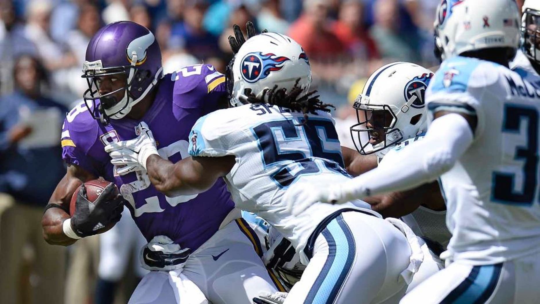 Minnesota Vikings running back Adrian Peterson tries to get past Tennessee Titans defenders including Sean Spence in the first half Sunday, Sept. 11, 2016, in Nashville, Tenn.