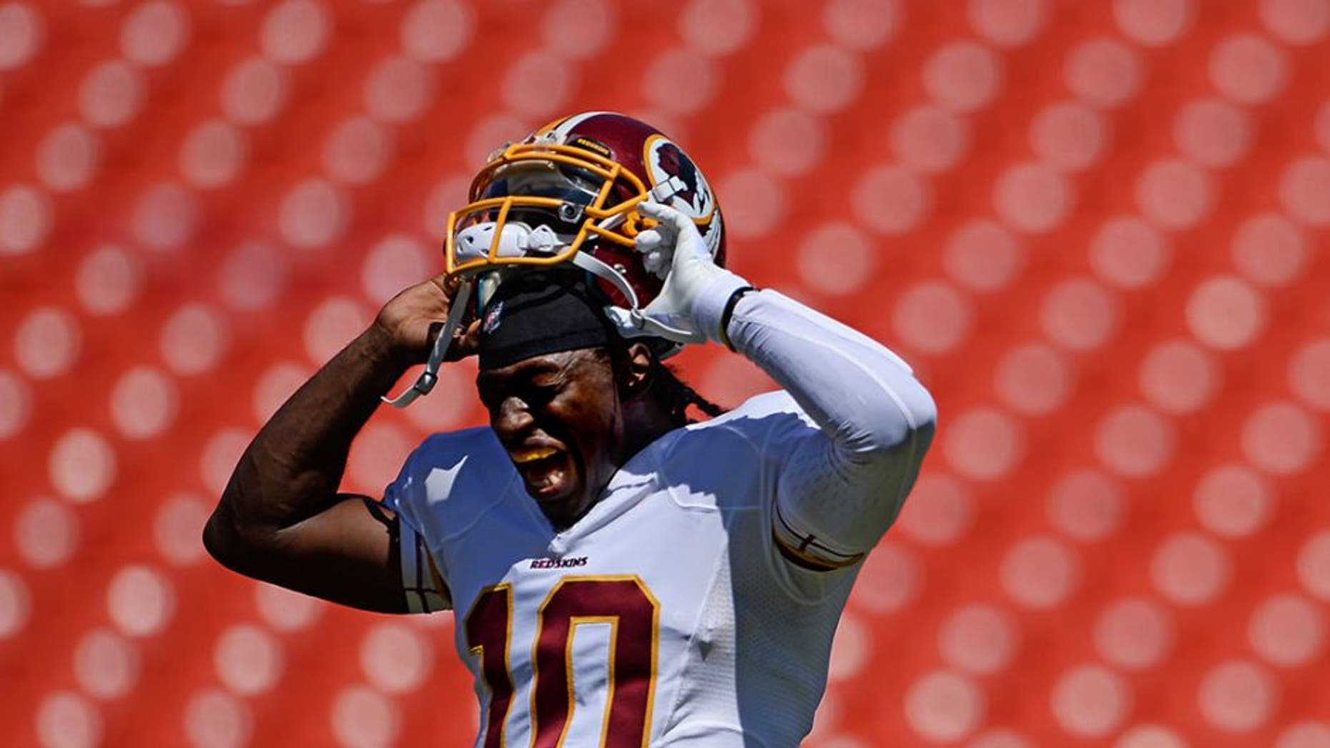 LANDOVER, MD - AUGUST 24: Quarterback Robert Griffin III #10 of the Washington Redskins takes off his helmet before playing the Buffalo Bills during a preseason game at FedExField on August 24, 2013 in Landover, Maryland. (Photo by Patrick Smith/Getty Images)