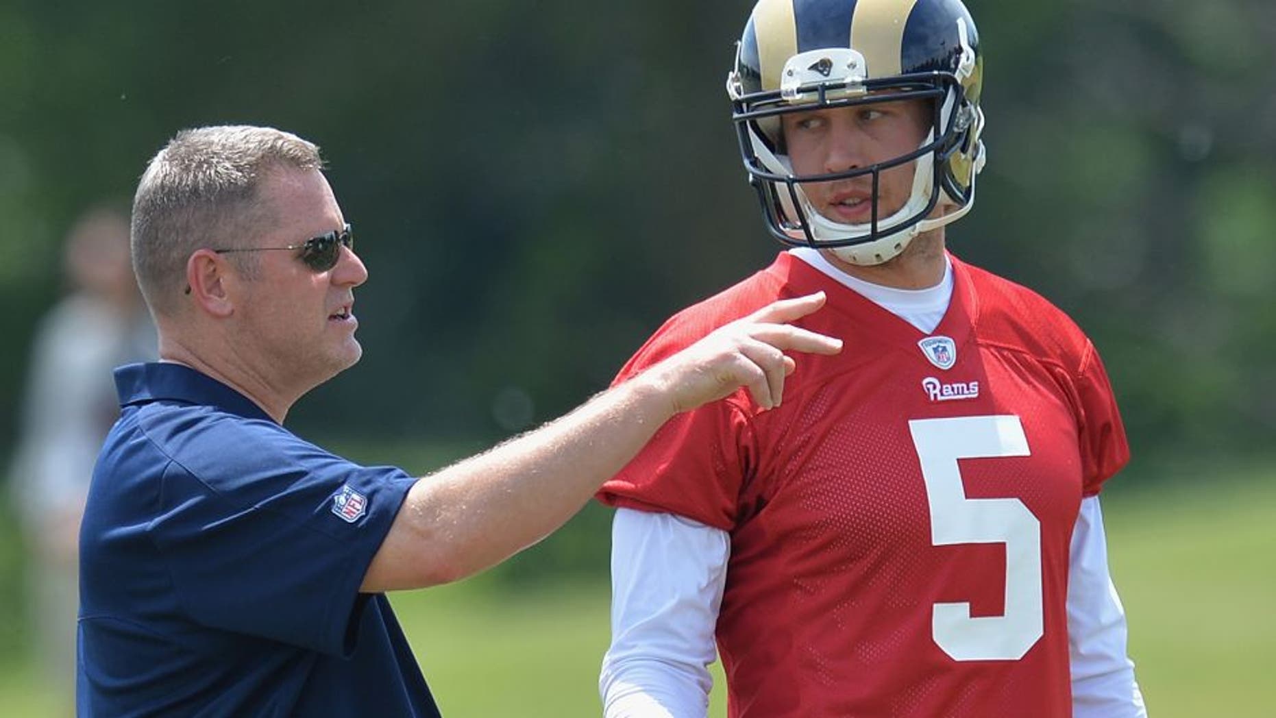 St. Louis Rams offensive coordinator Frank Cignetti talks to quarterback Nick Foles during an NFL football organized team activity, Thursday, June 11, 2015, in St. Louis. (AP Photo/Michael Thomas)