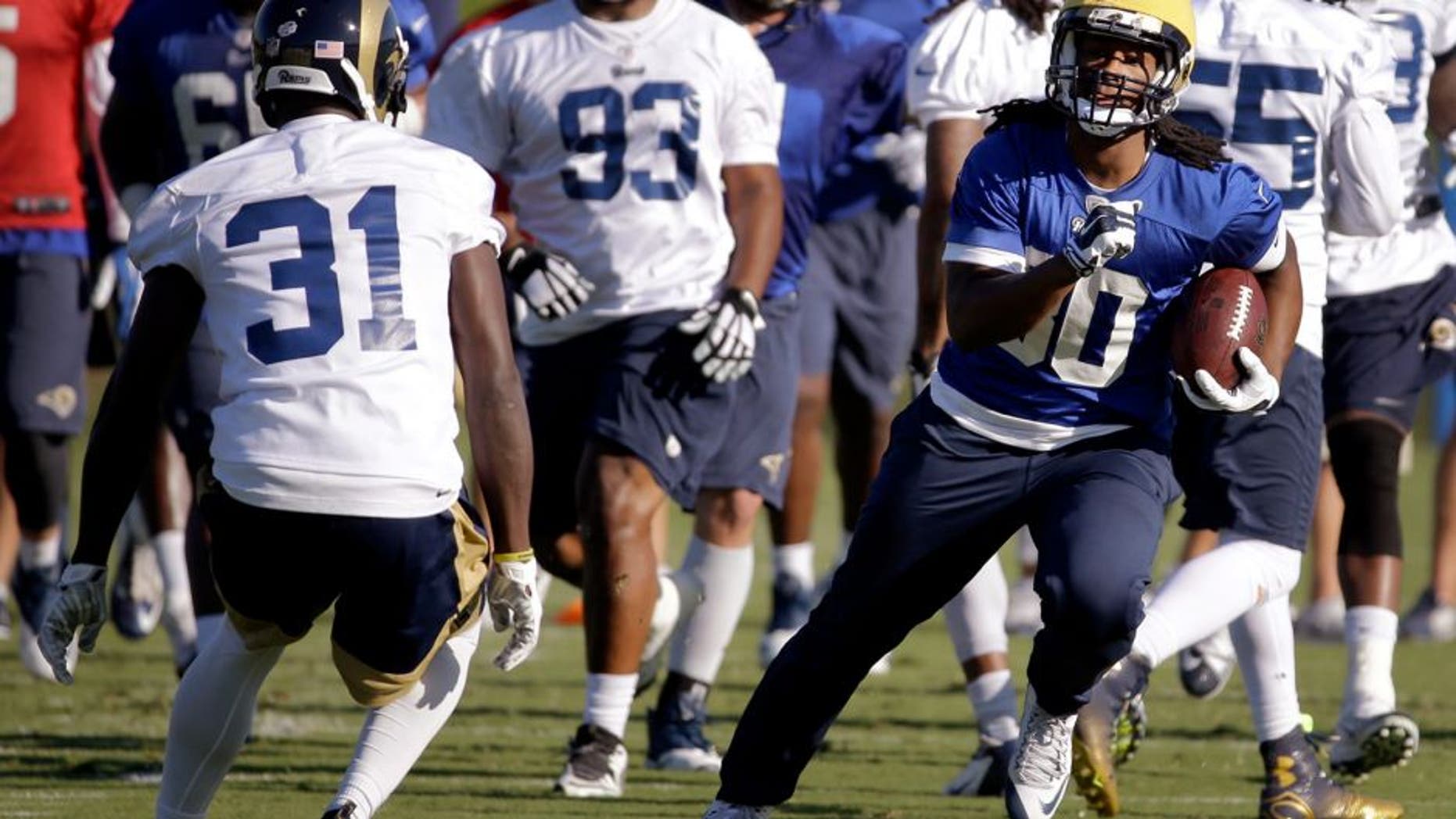 St. Louis Rams running back Todd Gurley, right, runs with the ball as safety Maurice Alexander (31) defends during training camp at the NFL football team's practice facility Tuesday, Aug. 25, 2015, in St. Louis. Gurley, who is rehabbing from left knee surgery that ended his college career, has been cleared to practice, but the 10th overall pick in the draft still won't play in the preseason. (AP Photo/Jeff Roberson)