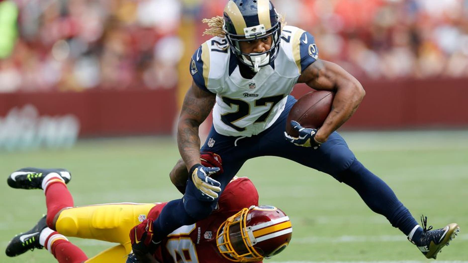Washington Redskins free safety Dashon Goldson (38) pulls St. Louis Rams running back Tre Mason (27) to the turf during the second half of an NFL football game in Landover, Md., Sunday, Sept. 20, 2015. (AP Photo/Patrick Semansky)