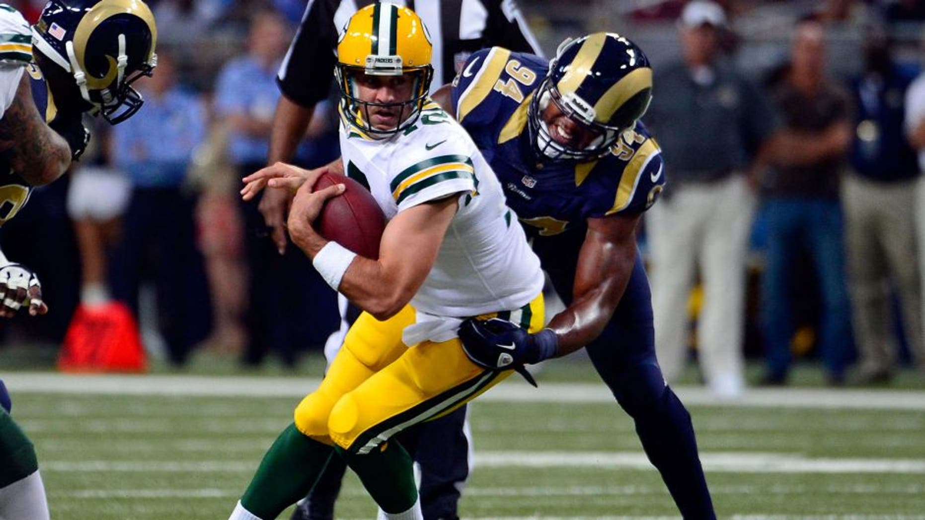 Aug 17, 2013; St. Louis, MO, USA; St. Louis Rams defensive end Robert Quinn (94) sacks Green Bay Packers quarterback Aaron Rodgers (12) during the first half at the Edward Jones Dome. Mandatory Credit: Scott Rovak-USA TODAY Sports