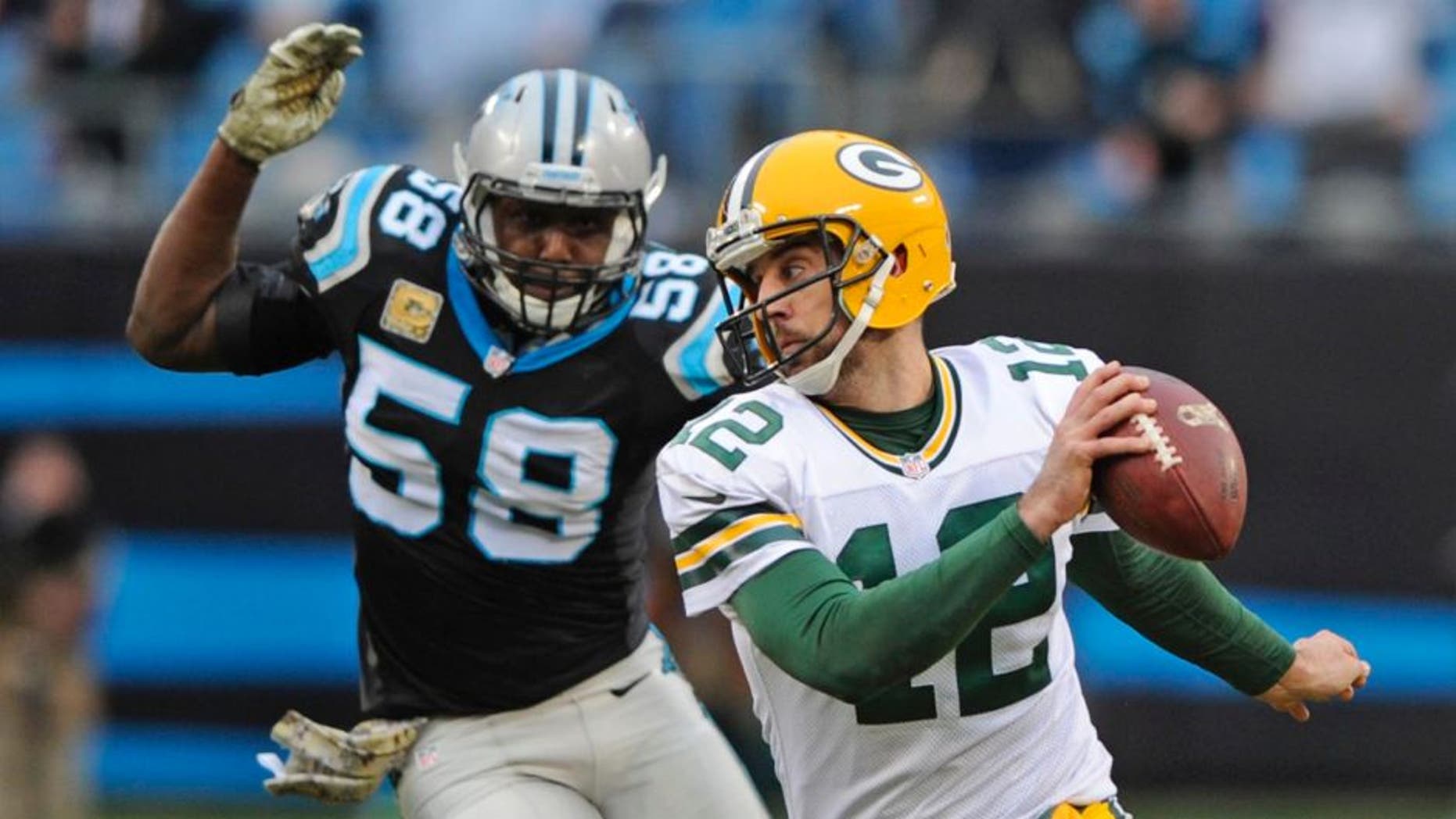 The Green Bay Packers' Aaron Rodgers scrambles as the Carolina Panthers' Thomas Davis pursues in the second half of an NFL football game in Charlotte, N.C., on Sunday, Nov. 8, 2015.