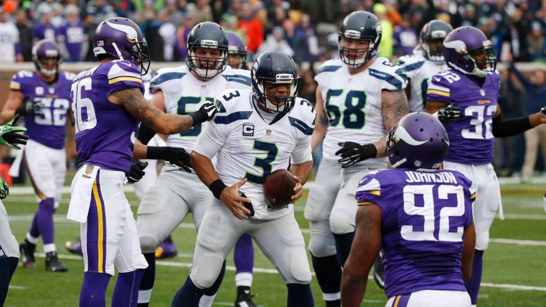 Seattle Seahawks quarterback Russell Wilson celebrates his 8-yard touchdown run against the Minnesota Vikings in the first half of an NFL football game Sunday, Dec. 6, 2015, in Minneapolis.