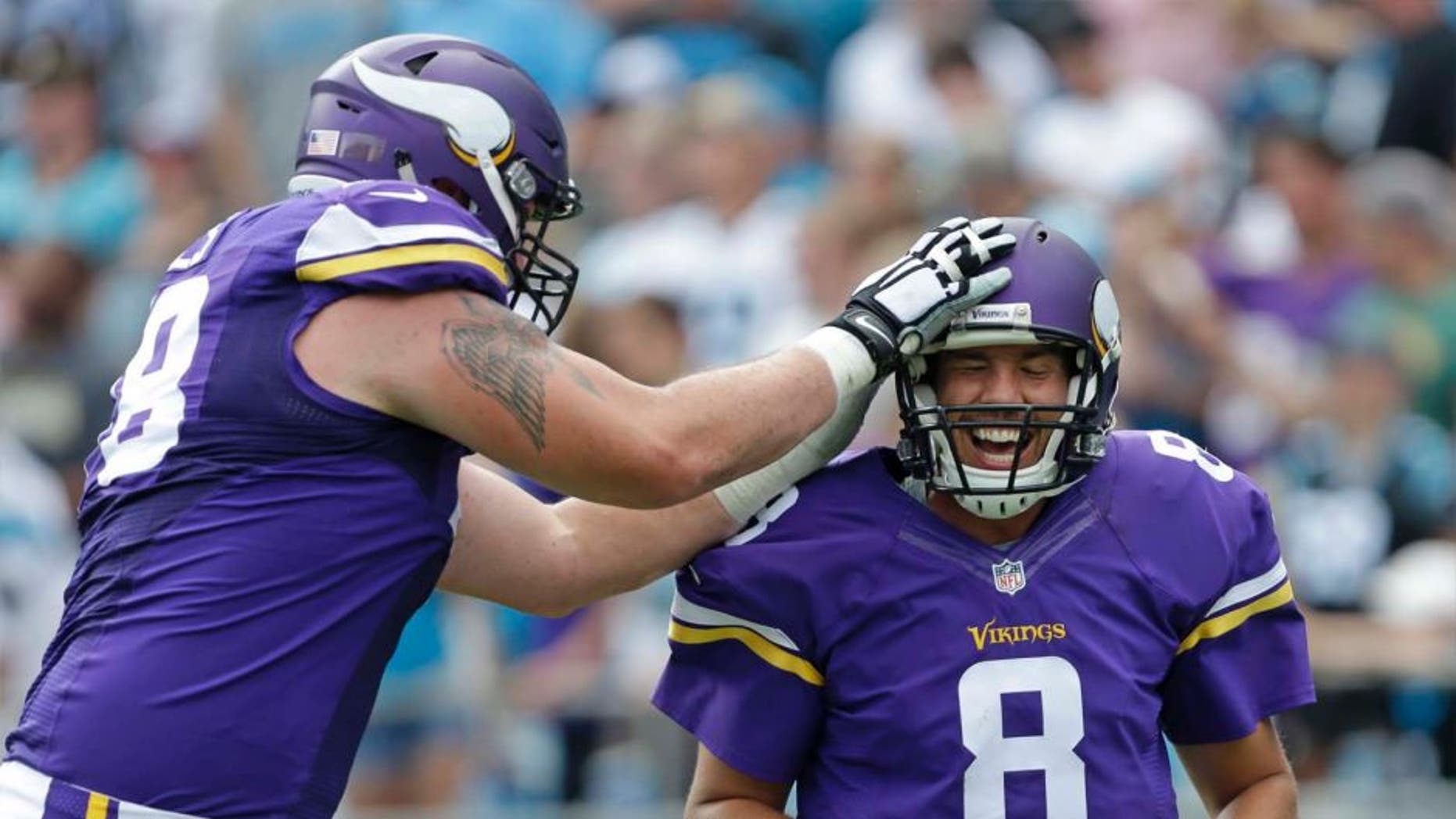 The Minnesota Vikings' Sam Bradford (right) is congratulated by Jeremiah Sirles after touchdown pass against the Carolina Panthers in the second half in Charlotte, N.C., Sunday, Sept. 25, 2016.