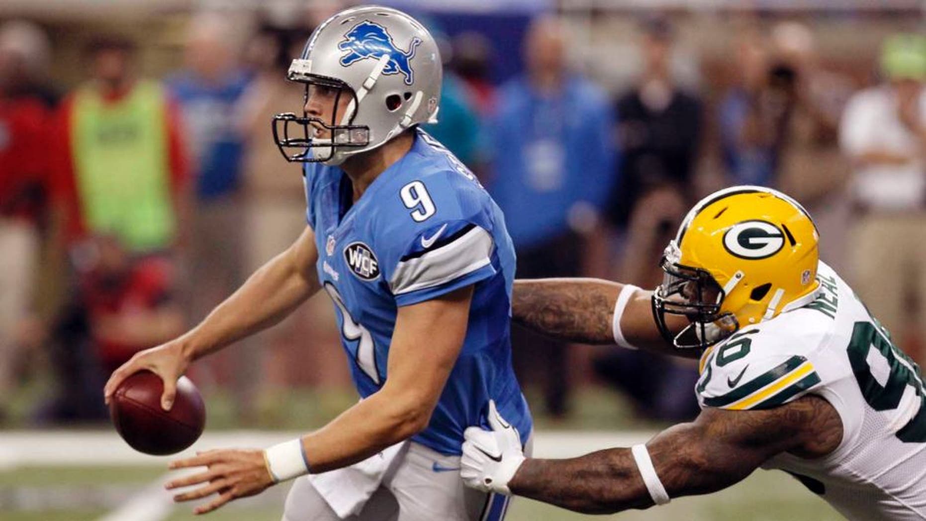 Green Bay Packers outside linebacker Mike Neal (right) reaches in on Detroit Lions quarterback Matthew Stafford during the first half.