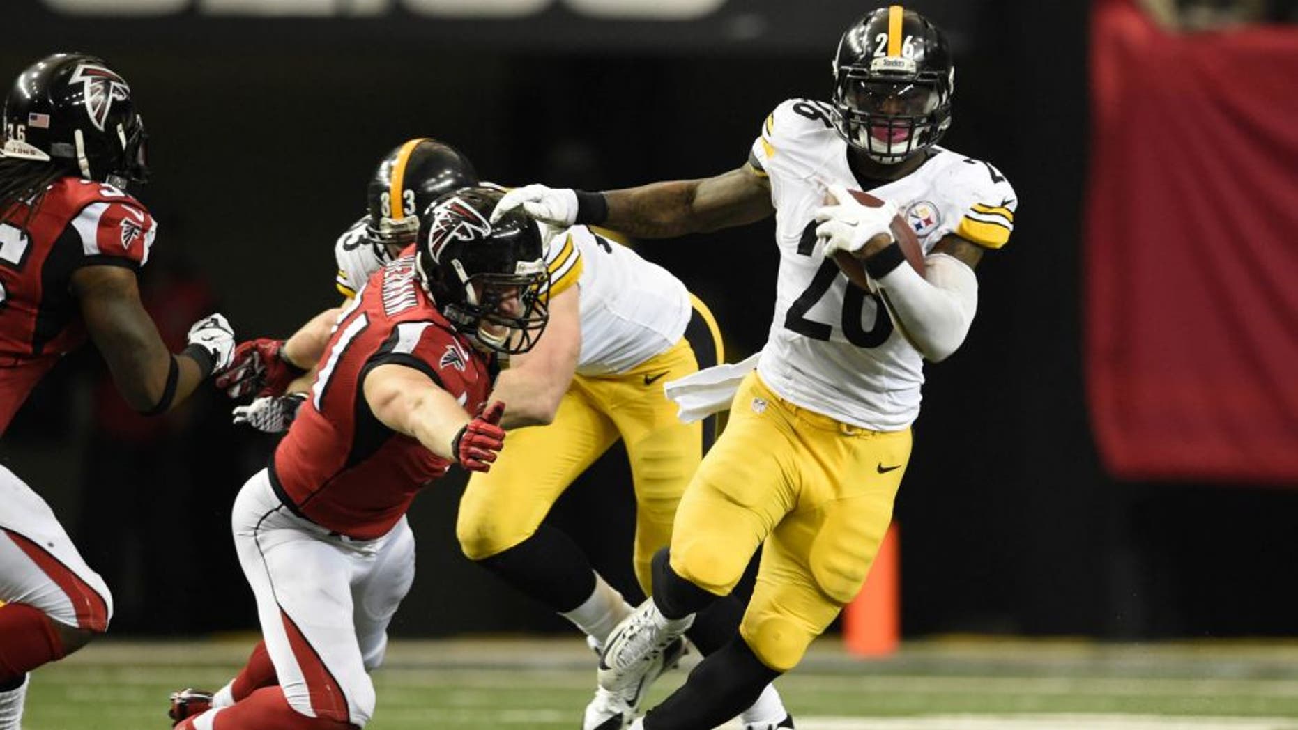 Dec 14, 2014; Atlanta, GA, USA; Pittsburgh Steelers running back Le'Veon Bell (26) carries the ball past Atlanta Falcons outside linebacker Kroy Biermann (71) in the fourth quarter at the Georgia Dome. Mandatory Credit: RVR Photos-USA TODAY Sports