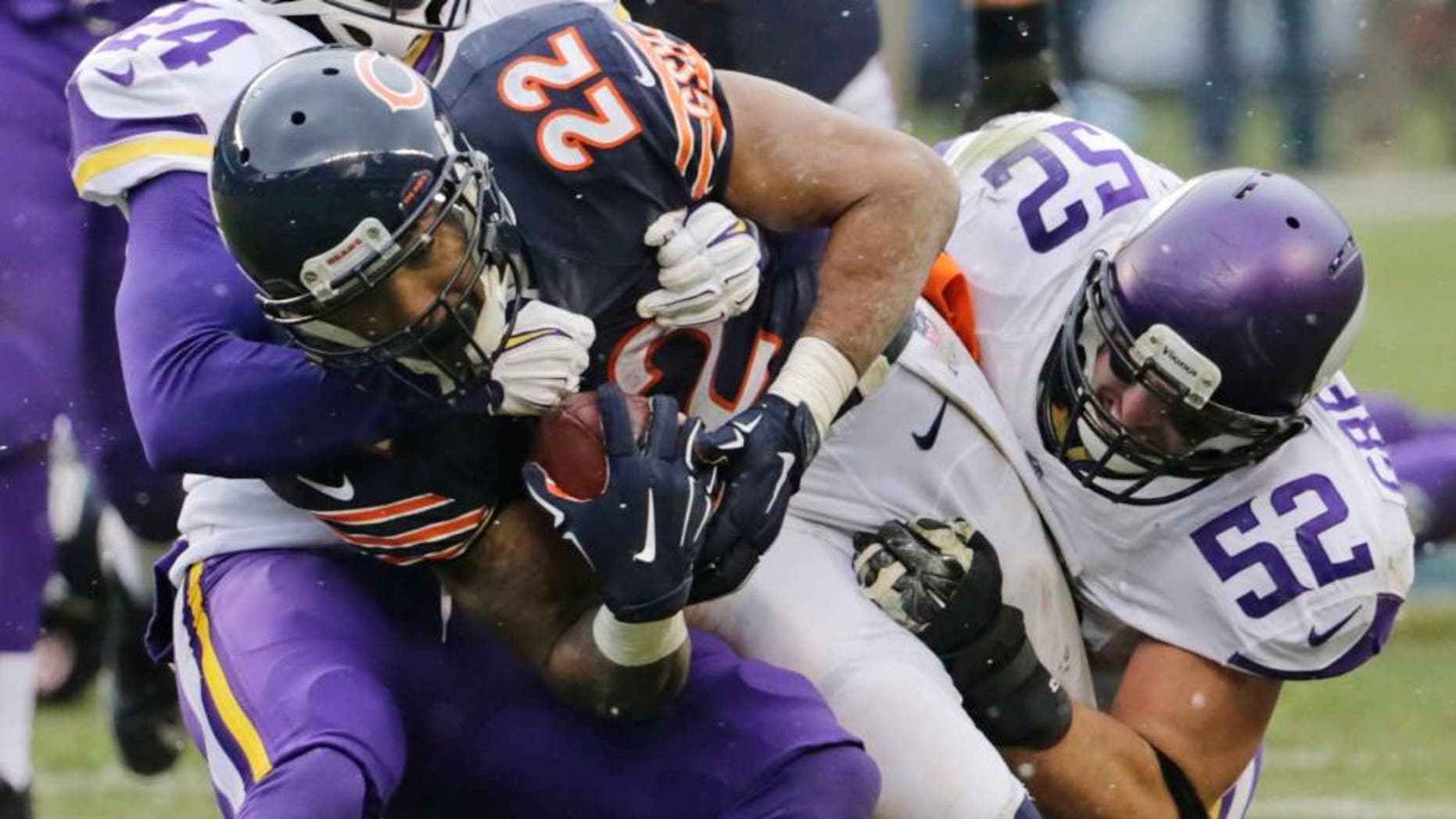 Chicago Bears running back Matt Forte (center) is tackled by Minnesota Vikings cornerback Captain Munnerlyn (left) and linebacker Chad Greenway (right) during the first half.