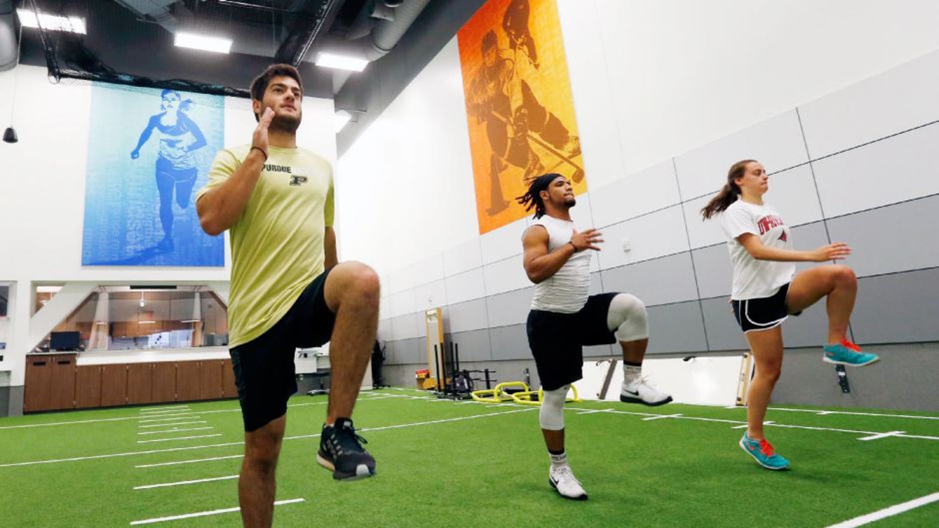 In this July 6, 2016 photo, from left, Stephen Kalina, Jaden Huff and Haley Nielsen go through workouts at the Mayo Clinic in Minneapolis. Mayo's new facility for high-level conditioning with noted performance trainer EXOS isn't just for elite athletes anymore. The general public can sign up for workouts similar to what NFL prospects take part in preparing for the combine, and weekend warriors are getting in more than just a good sweat before going to the office.