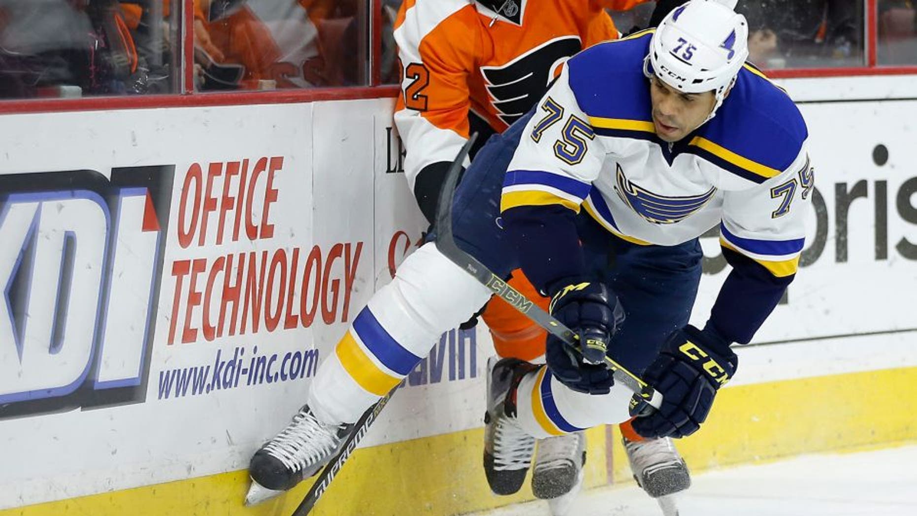 St. Louis Blues' Ryan Reaves (75) and Philadelphia Flyers' Luke Schenn (22) chase after a loose puck during the first period of an NHL hockey game, Monday, Dec. 21, 2015, in Philadelphia. (AP Photo/Matt Slocum)