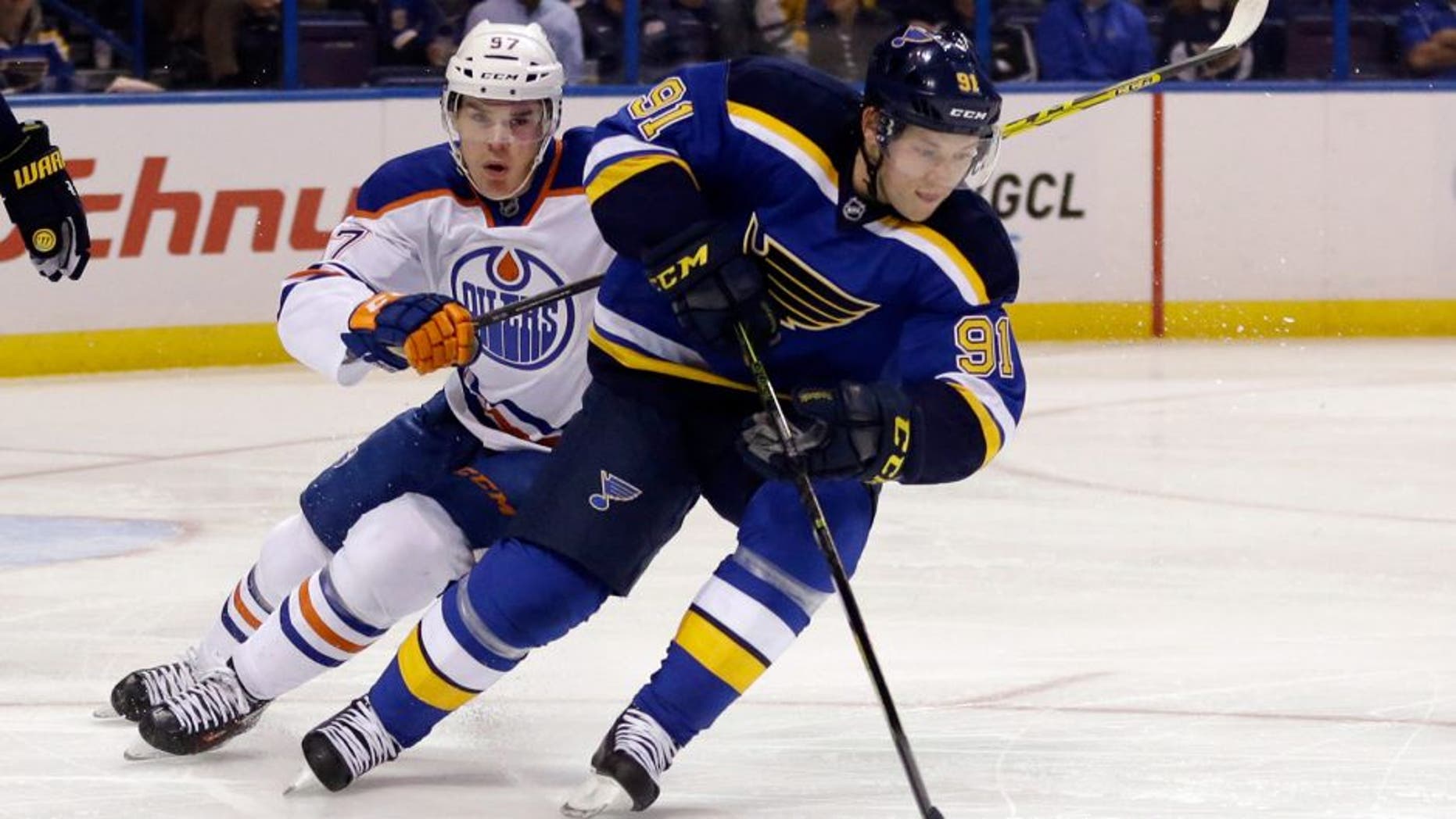 St. Louis Blues' Vladimir Tarasenko, right, of Russia, controls the puck as Edmonton Oilers' Connor McDavid, left, pursues during the first period of an NHL hockey game Thursday, Oct. 8, 2015, in St. Louis. (AP Photo/Jeff Roberson)