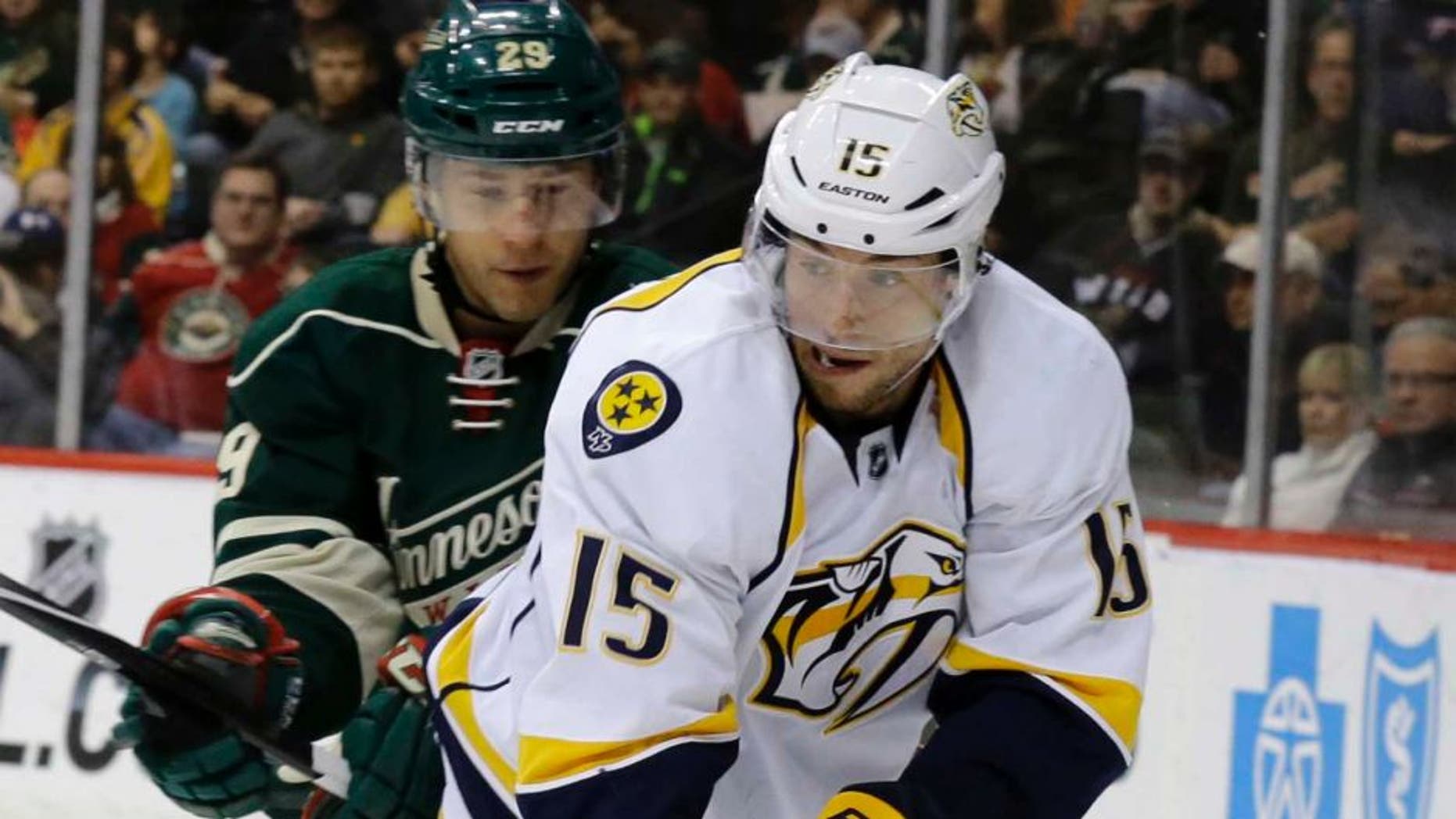 Nashville Predators center Craig Smith (right) controls the puck in front of Minnesota Wild right wing Jason Pominville during the second period.