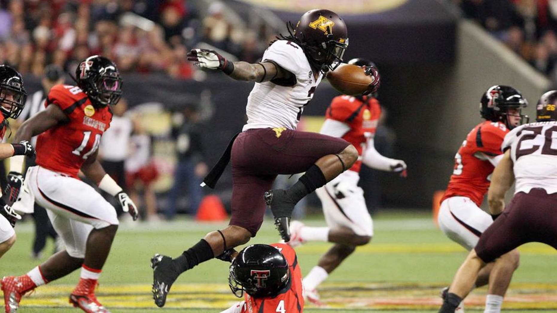 Dec 28, 2012; Houston, TX, USA; Minnesota Golden Gophers defensive back Troy Stoudermire (2) leaps over a defender on a kickoff return against the Texas Tech Red Raiders during the first quarter of the Car Care Bowl at Reliant Stadium. Mandatory Credit: Troy Taormina-USA TODAY Sports