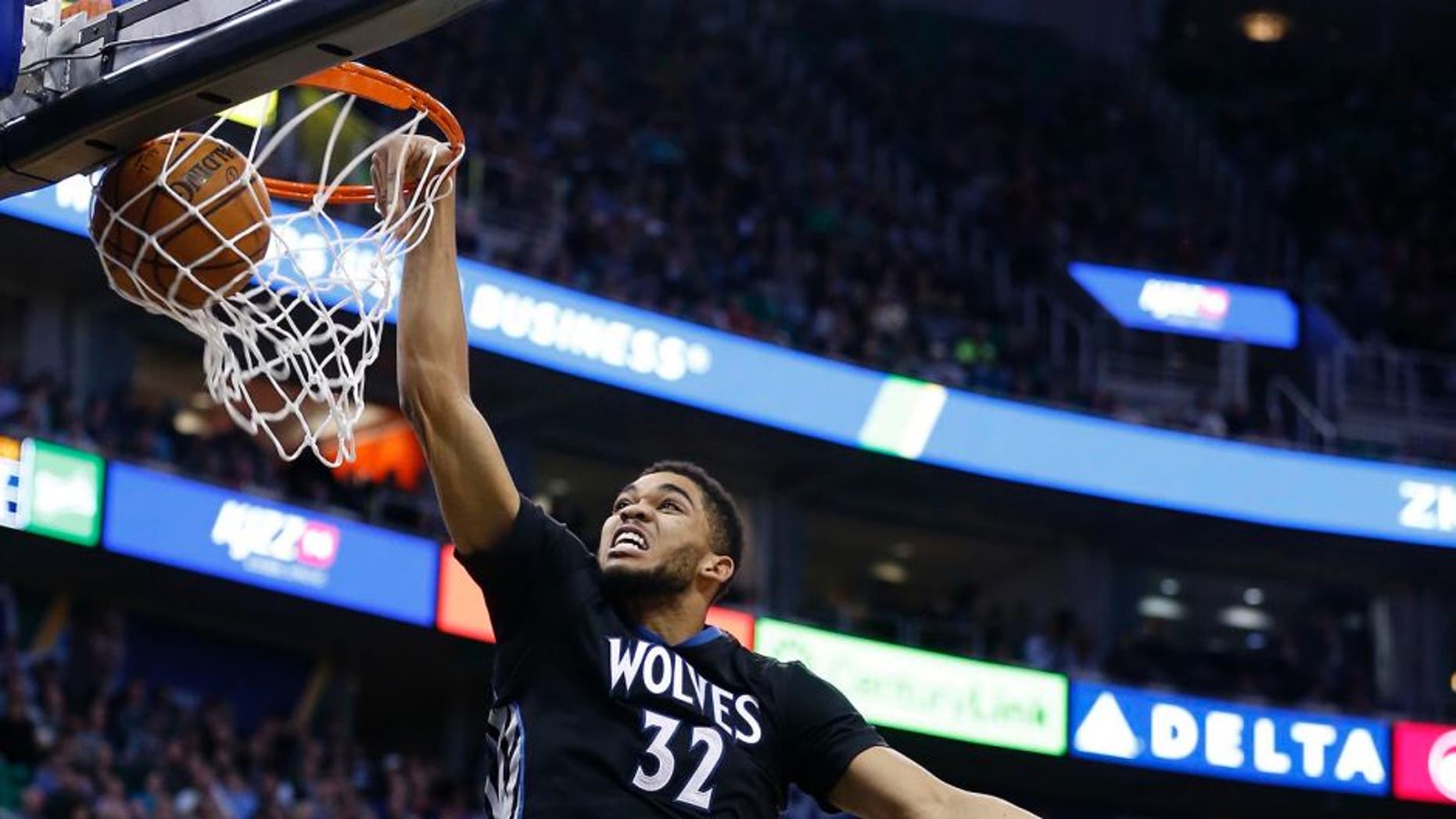 Jan 29, 2016; Salt Lake City, UT, USA; Minnesota Timberwolves center Karl-Anthony Towns (32) dunks the ball in the second quarter against Utah Jazz forward Derrick Favors (15) and center Rudy Gobert (27) at Vivint Smart Home Arena. Mandatory Credit: Jeff Swinger-USA TODAY Sports