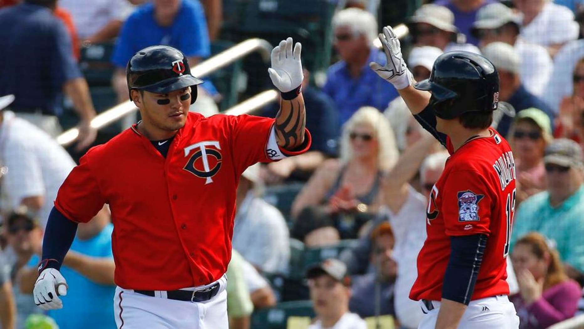 Minnesota Twins' Byung Ho Park, left, of South Korea, high-fives teammate John Ryan Murphy after hitting a solo home run in the fourth inning of a spring training interleague baseball game against the Miami Marlins in Fort Myers, Fla., Friday, March 11, 2016. (AP Photo/Patrick Semansky)