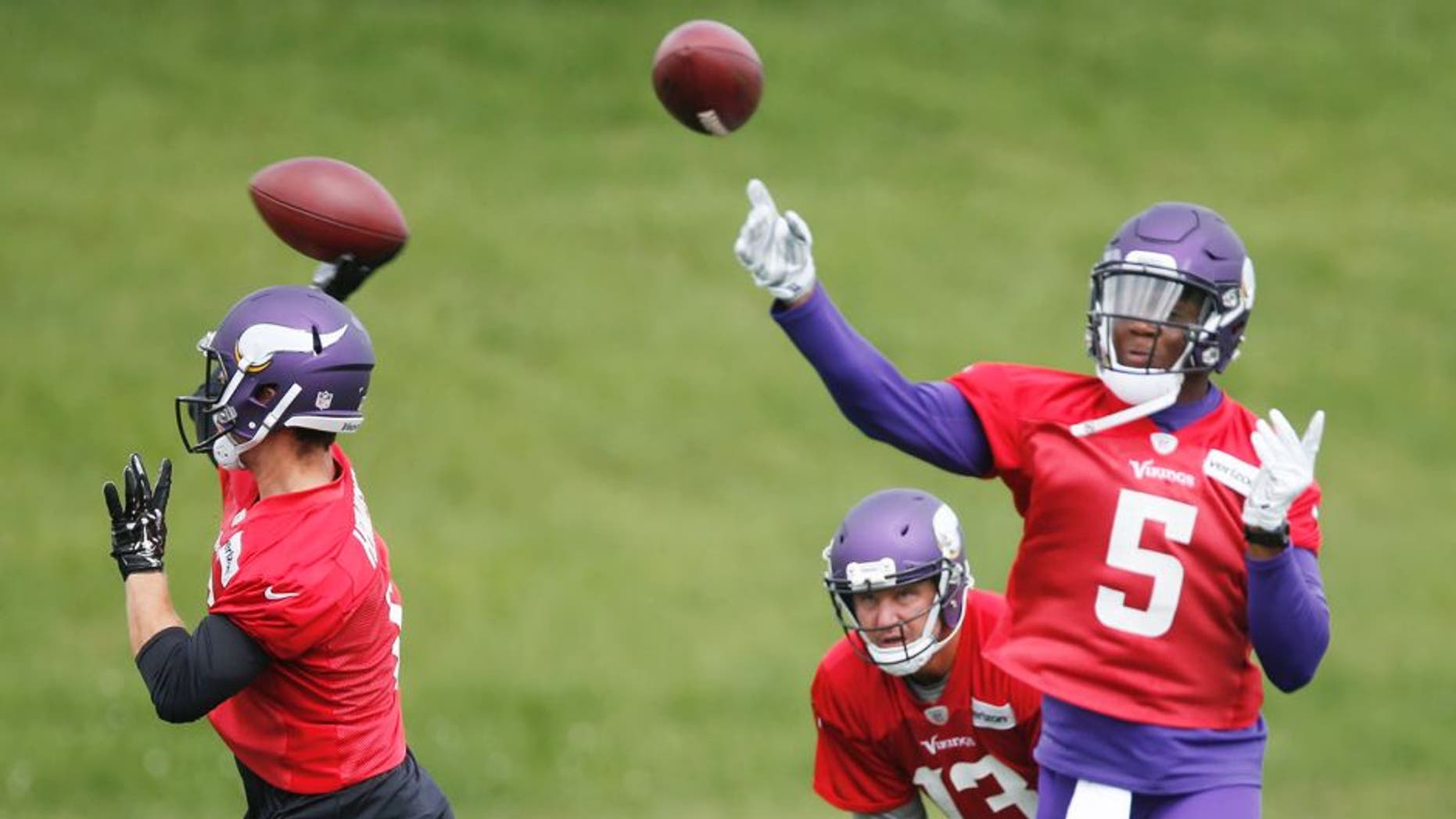 CORRECTS YEAR -Minnesota Vikings quarterbacks Teddy Bridgewater, right, and Taylor Heinicke throw during the NFL football team's minicamp Wednesday, June 15, 2016, in Eden Prairie, Minn. Watching, bottom center, is quarterback Shaun Hill. (AP Photo/Jim Mone)