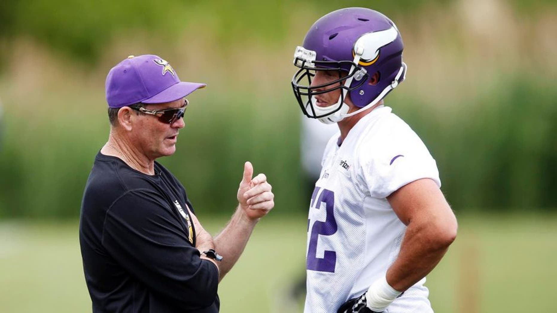 Minnesota Vikings head coach Mike Zimmer visits with linebacker Chad Greenway.