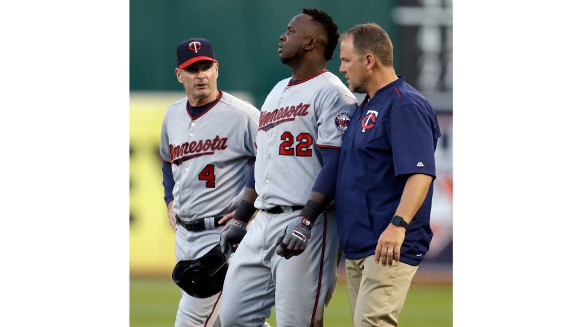 Minnesota Twins manager Paul Molitor, left, and a trainer walk Miguel Sano off the field after an injury sustained in the third inning of a baseball game against the Oakland Athletics.