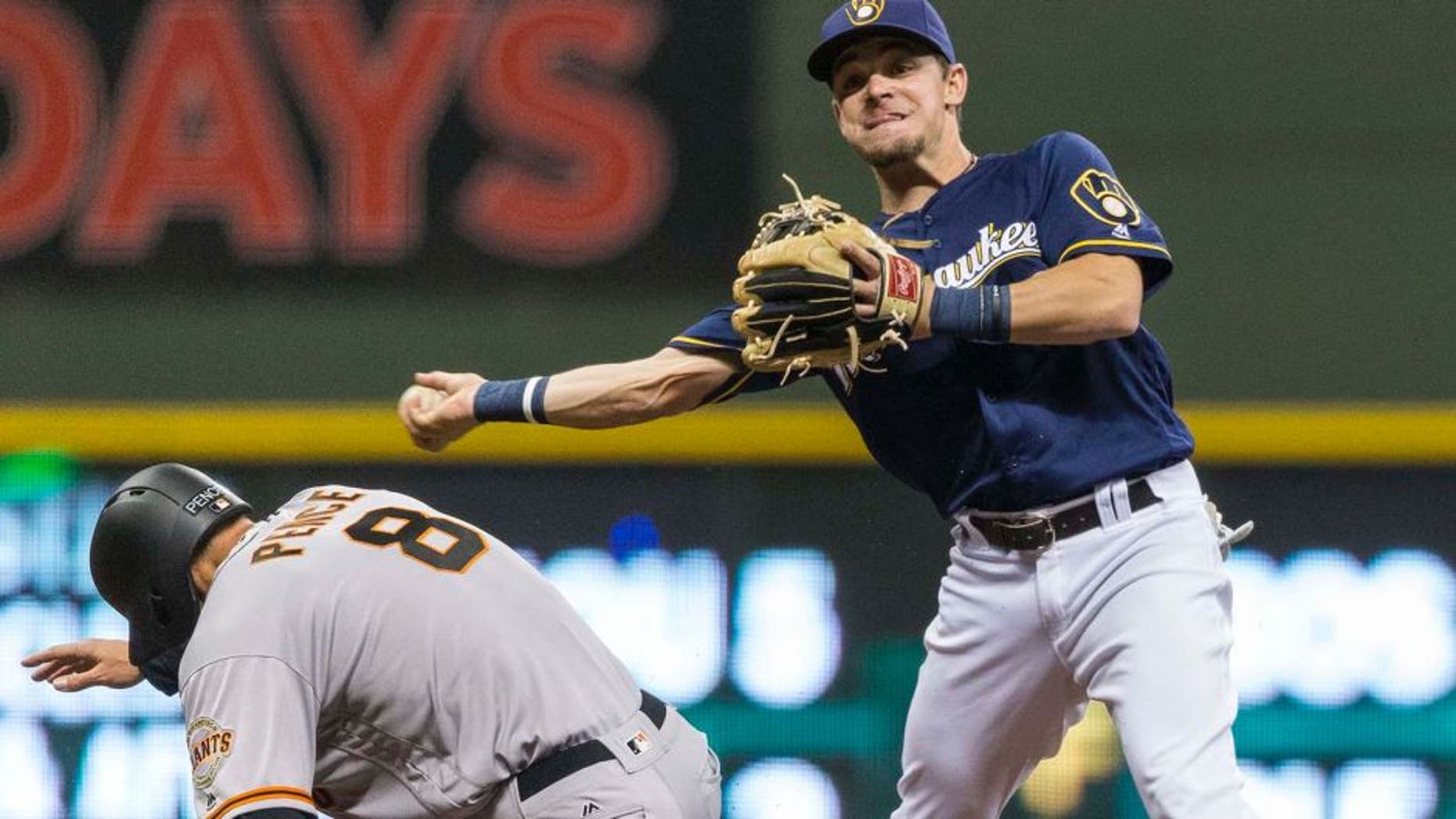 Milwaukee Brewers' Scooter Gennett throws to first after forciong out San Fransisco Giants' Hunter Pence during the fourth inning of a baseball game Tuesday, April 5, 2016, in Milwaukee. Matt Duffy was safe at first, and an run scored. (AP Photo/Tom Lynn)