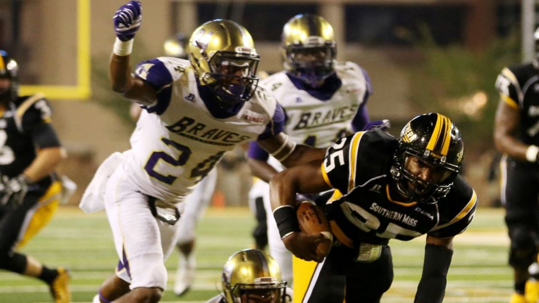 Southern Miss Golden Eagles running back Ito Smith runs with the ball as Alcorn State Braves defensive backs Warren Gatewood and Devon Francois close in.