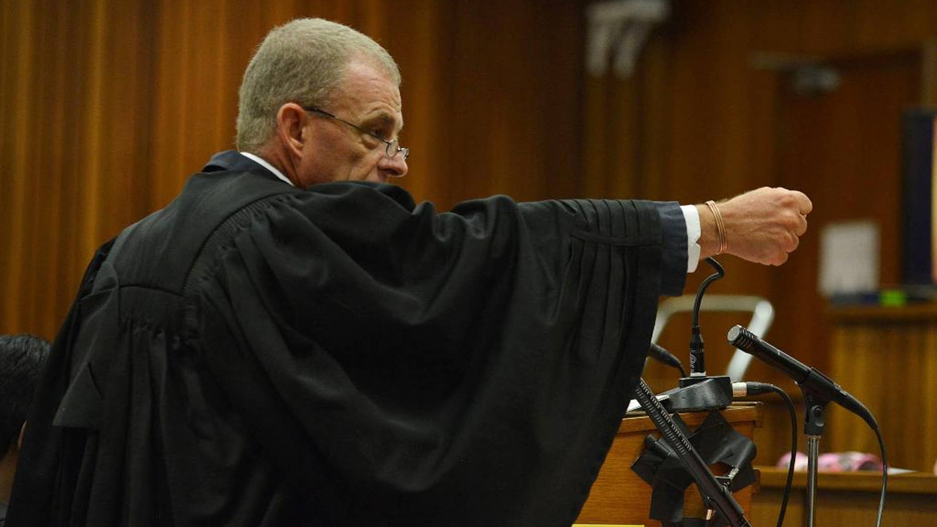 El fiscal Gerrie Nel gesticula al explicar el posible escenario de cómo Oscar Pistorius habría disparado a su novia, en el juicio contra el atleta el lunes, 14 de abril de 2014, en Pretoria, Sudáfrica. (AP Photo/Antoine de Ras, Pool)