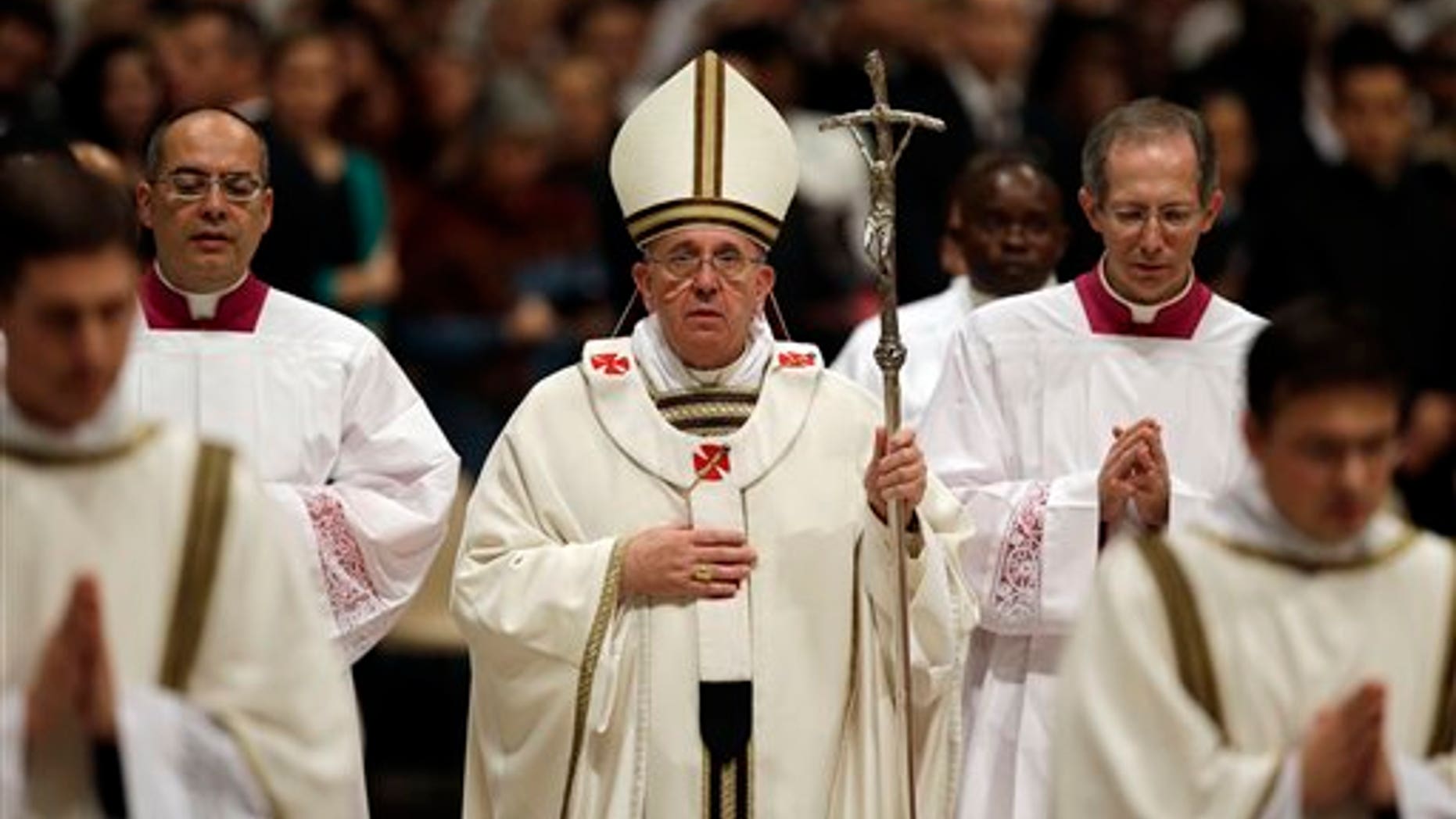 Pope Francis walks with the pastoral staff at the end of the Christmas Eve Mass in St. Peter's Basilica at the Vatican, Tuesday, Dec. 24, 2013. (AP Photo/Gregorio Borgia)