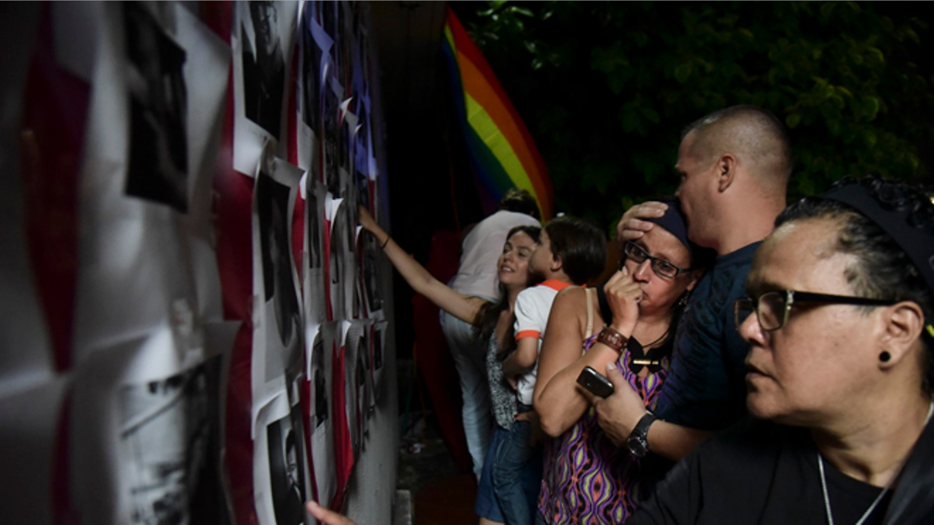 Residents look at photos of the victims during a vigil to honor the memory of the Puerto Ricans that died in the mass shooting at a nightclub in Orlando, Fla., at the Hato Rey LGBTT Community Center in San Juan, Puerto Rico, Tuesday, June 14, 2016. Dozens of people died at the 'Pulse' gay nightclub in Orlando, making it the deadliest mass shooting in modern U.S. history. (AP Photo/Carlos Giusti)