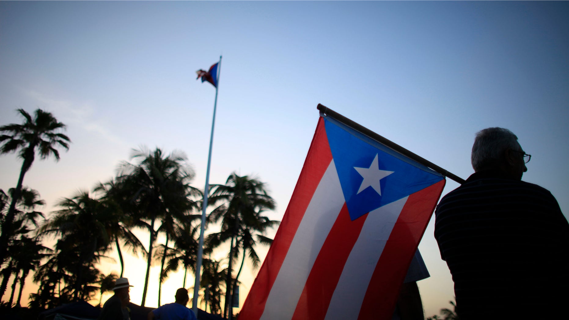 FILE - In this April 30, 2015, file photo, people gather in front of the Puerto Ricoâs Capitol building to protest against Gov. Alejandro Garcia Padilla's budget proposal for the next fiscal year in San Juan. Authorities announced on Monday, Jan. 18, 2016, that Puerto Rico's worsening economic crisis has forced it to revise a fiscal reform plan to reflect a jump in the island's projected deficit and a steep drop in anticipated revenue. (AP Photo/Ricardo Arduengo, File)