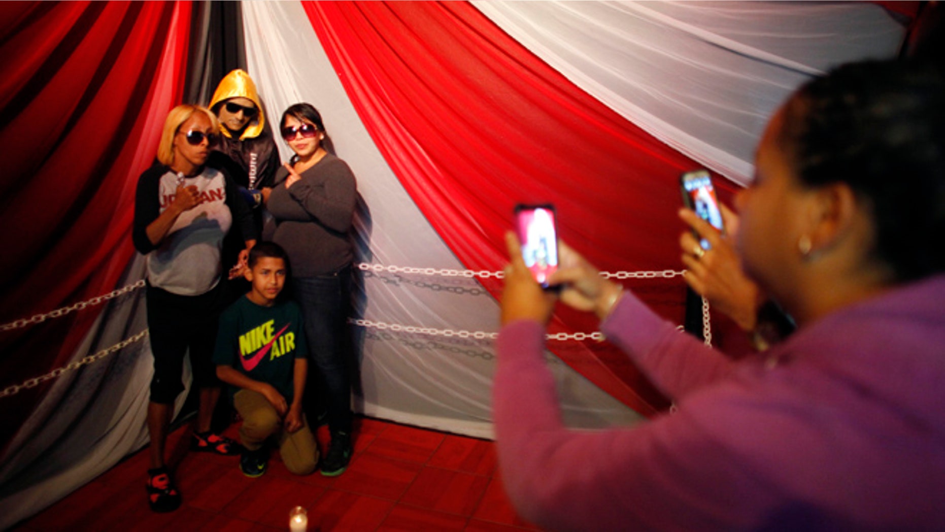Jan. 31: Lidianette Carmona, behind right, the wife of the late boxer Christopher Rivera, stands with Rivera's family as they pose for photos taken by fans with Rivera's body propped up in a fake boxing ring during his wake at the community recreation center within the public housing project where he lived in San Juan, Puerto Rico.