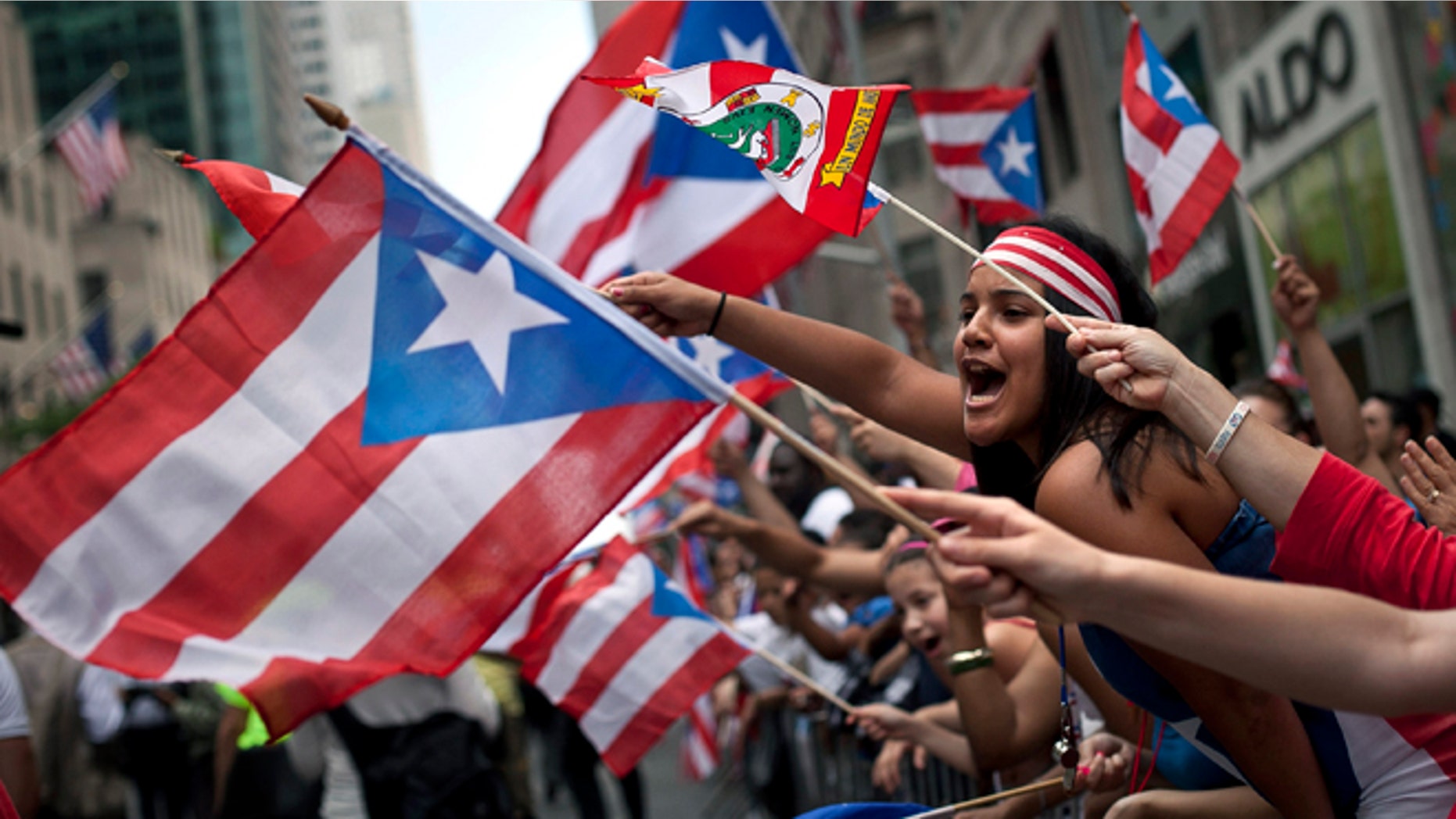 NEW YORK, NEW YORK - JUNE 10: Revelers gather along Fifth Avenue during the Puerto Rican Day Parade on June 10, 2012 in New York City. The Puerto Rican Day Parade draws hundreds of thousands and was first celebrated in New York City in 1958. (Photo by Allison Joyce/Getty Images)