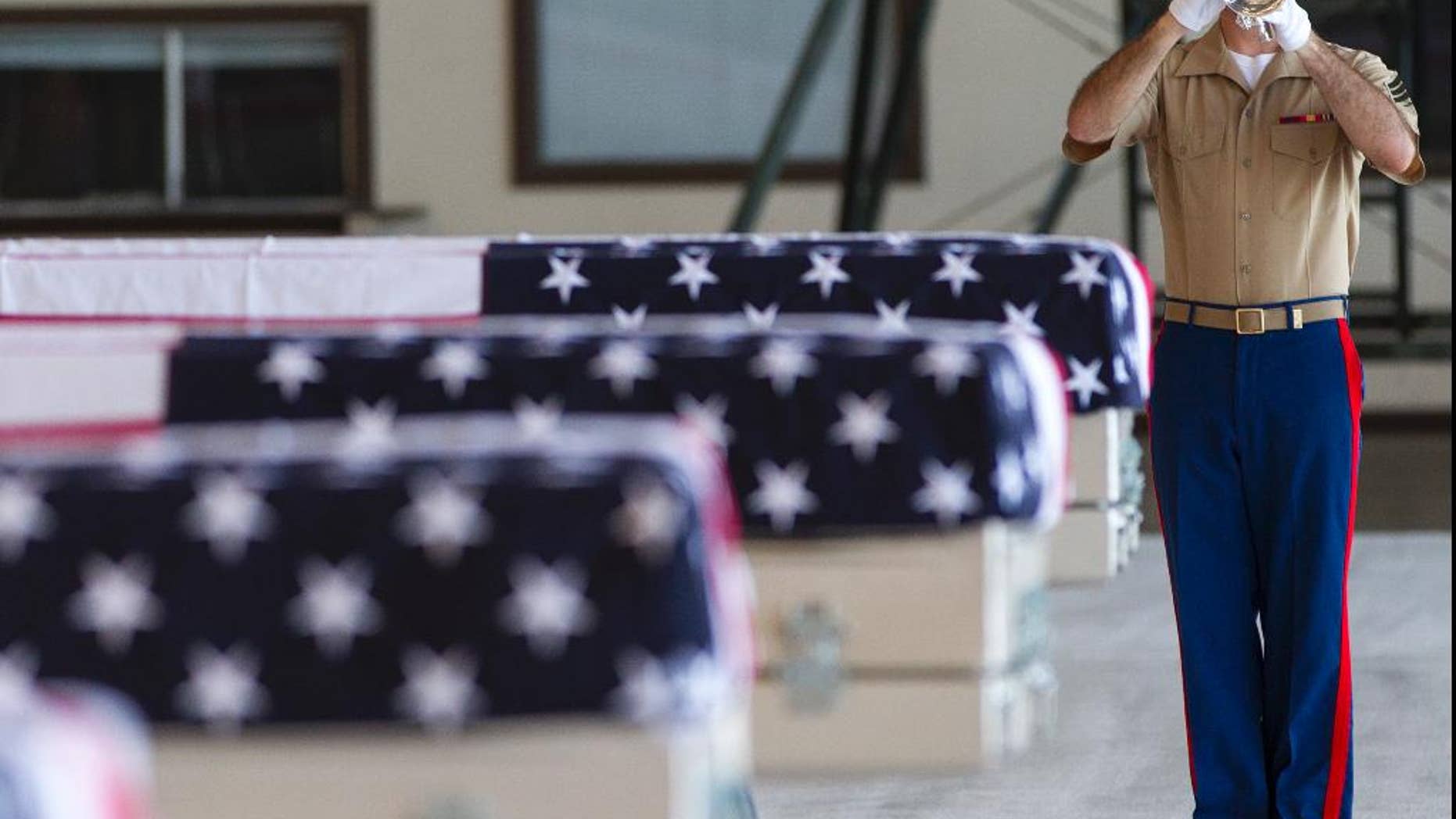 U.S. Marine Sgt. Nolan Luckett plays a bugle during a ceremony honoring 36 unidentified Marines found last year at the Pacific atoll of Tarawa.