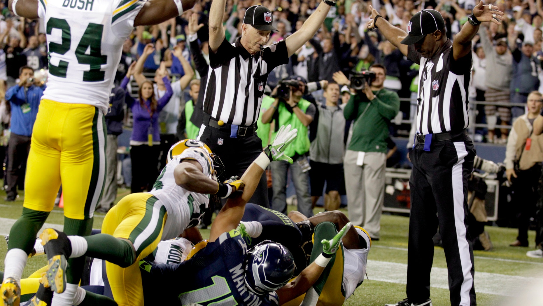 Sept. 24, 2012: Officials signal a touchdown by Seattle Seahawks wide receiver Golden Tate, obscured, on the last play of an NFL football game against the Green Bay Packers.