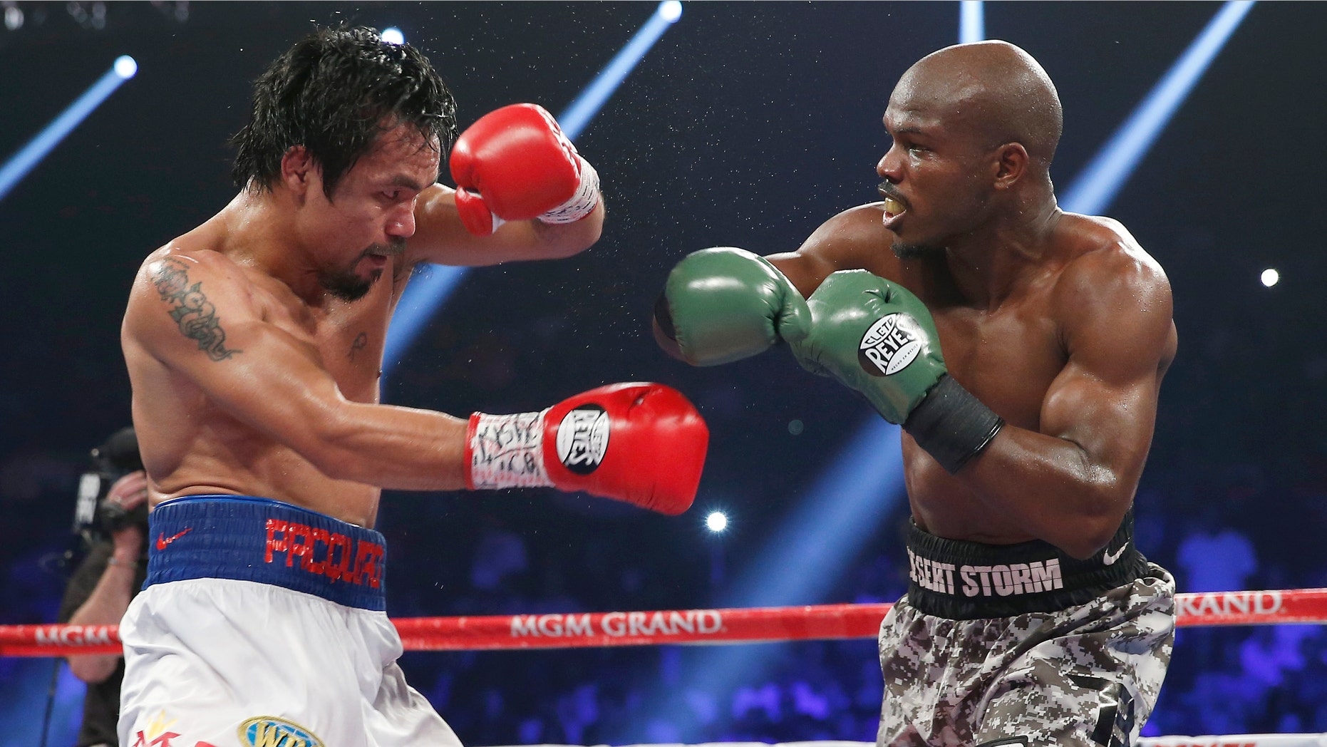 Manny Pacquiao, left, of the Philippines shields himself as Timothy Bradley throws a punch during the WBO welterweight title boxing fight Saturday, April 12, 2014, in Las Vegas. (AP Photo/Eric Jamison)