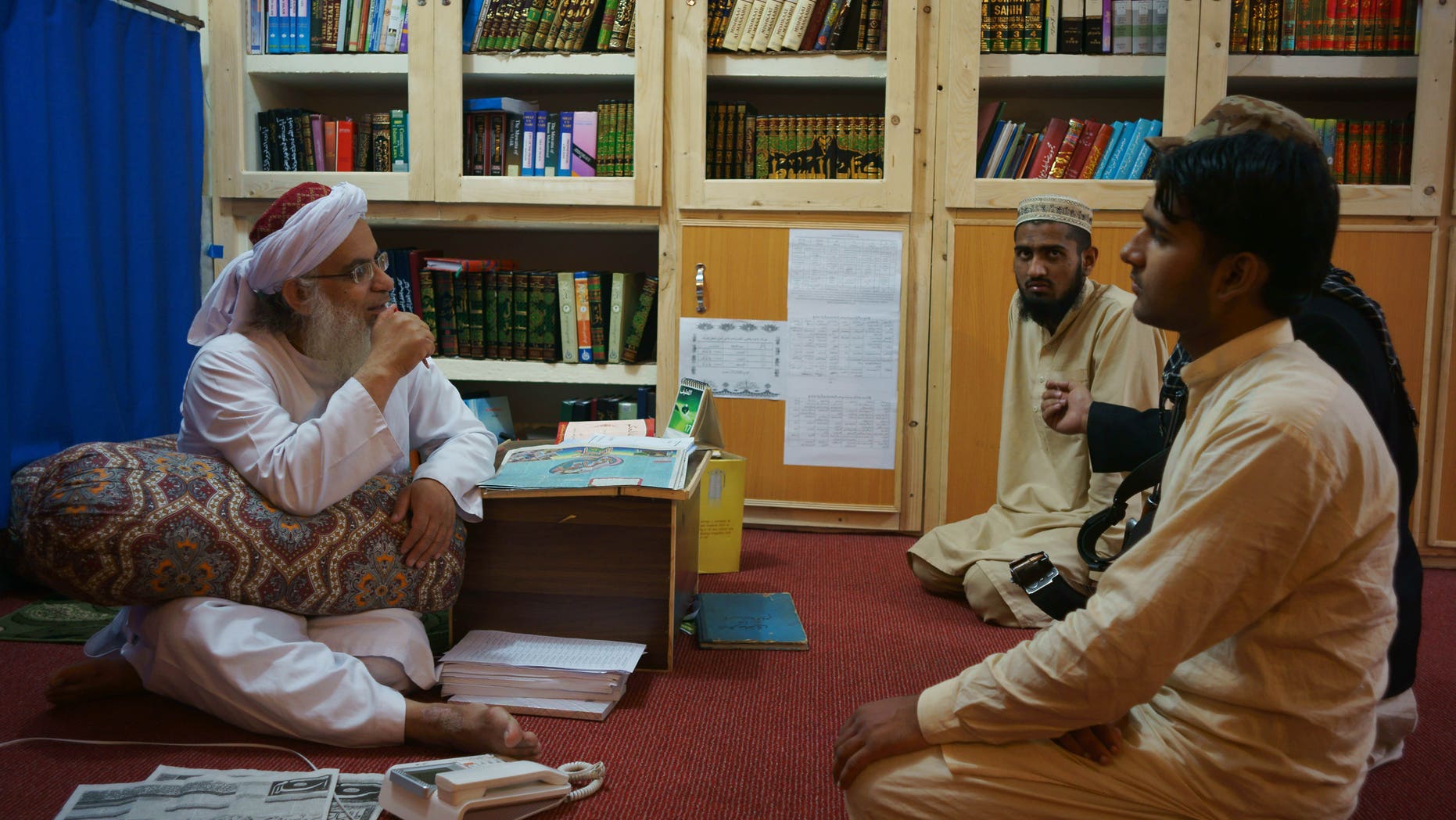 April 18, 2014 - Maulana Abdul Aziz, left, head cleric of a Pakistani seminary, in a library named after slain al Qaeda leader Usama bin Laden in Islamabad, Pakistan.